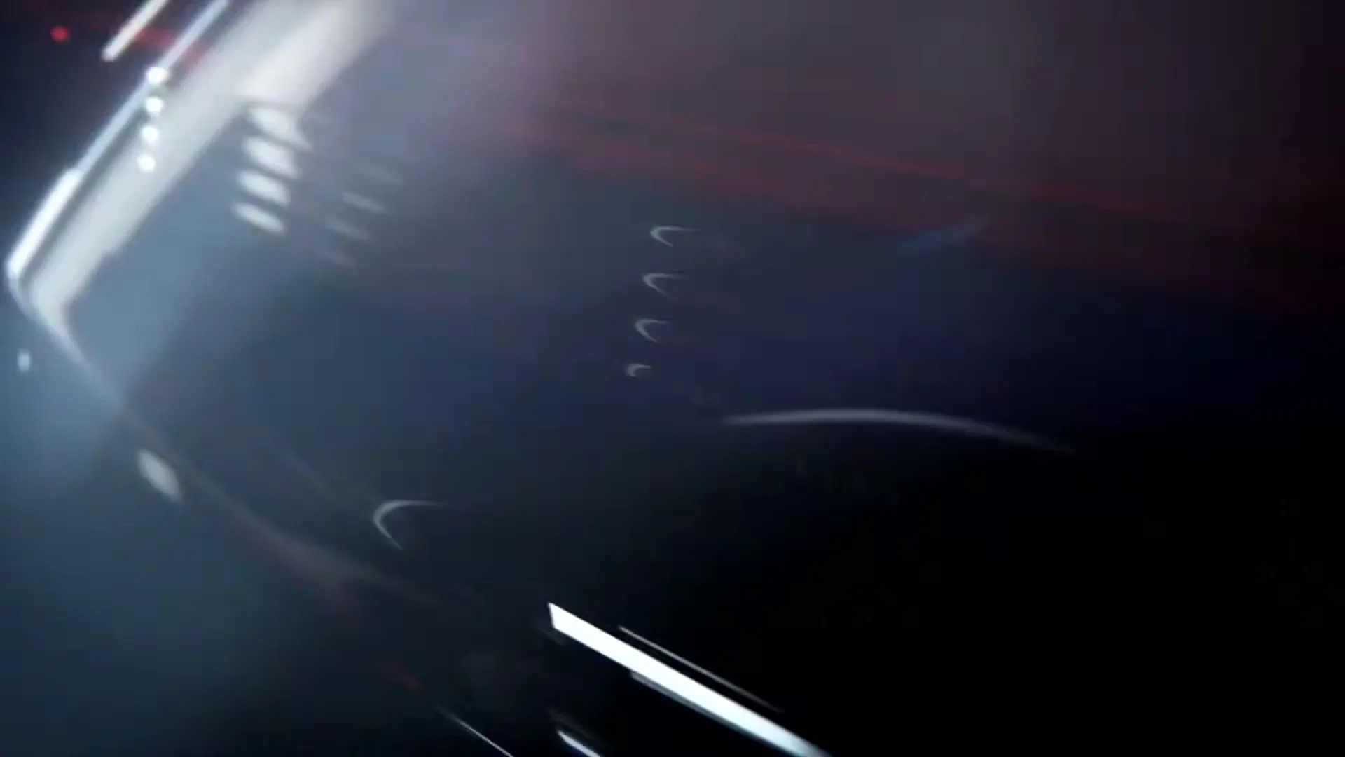 A close-up shot of a dark, glossy car surface with abstract red and white light streaks, suggesting speed and motion.