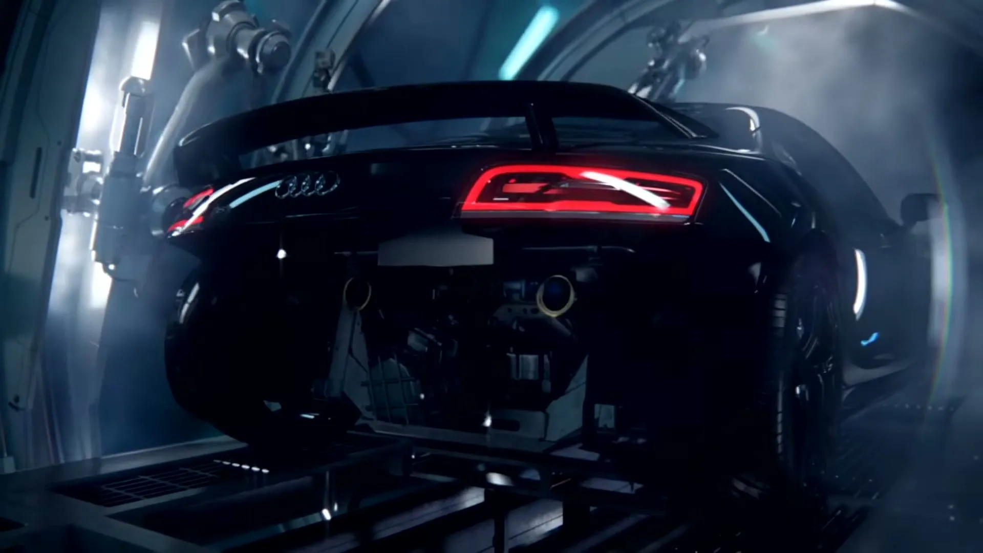 A black Audi R8 sports car is seen from the rear, with its taillights glowing red, in a futuristic, smoky industrial setting.