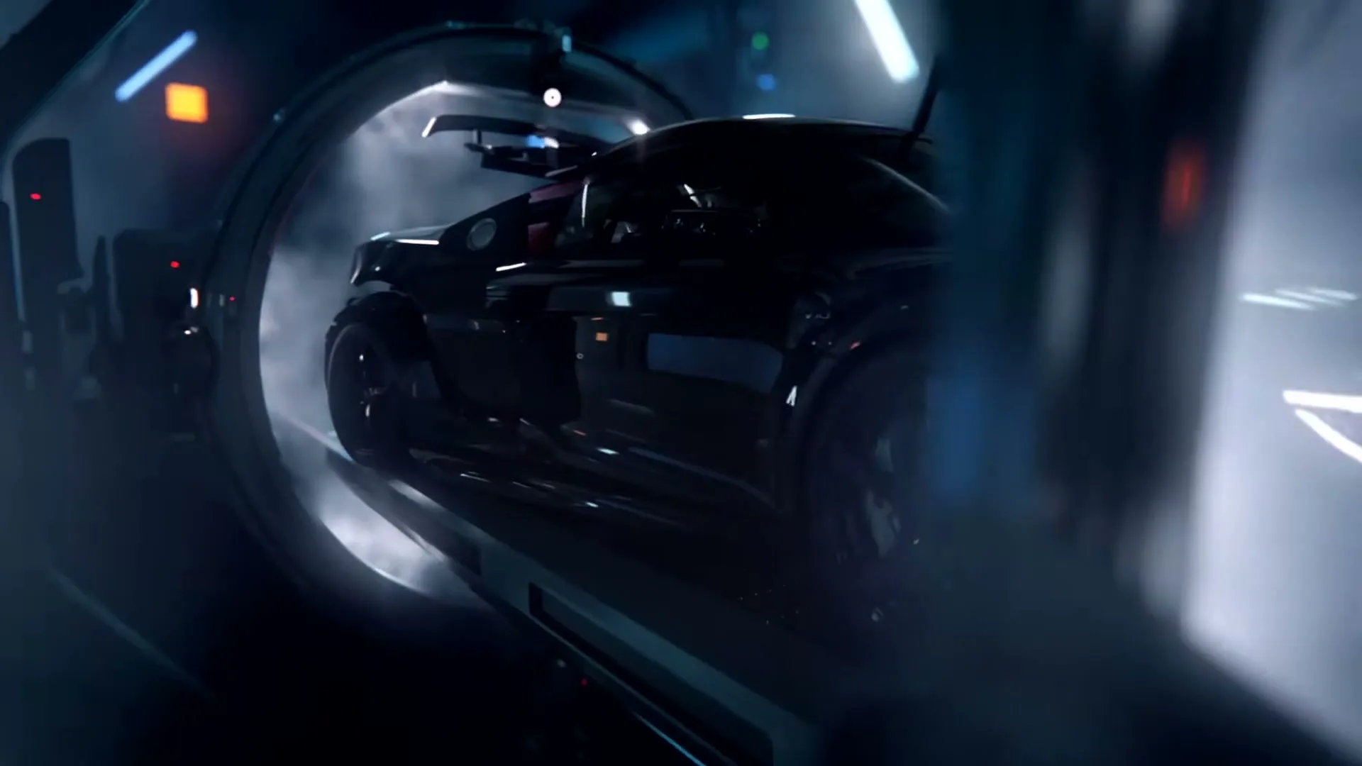 A sleek, dark sports car emerges from a futuristic, glowing tunnel, surrounded by smoke and bright lights in a high-tech facility.