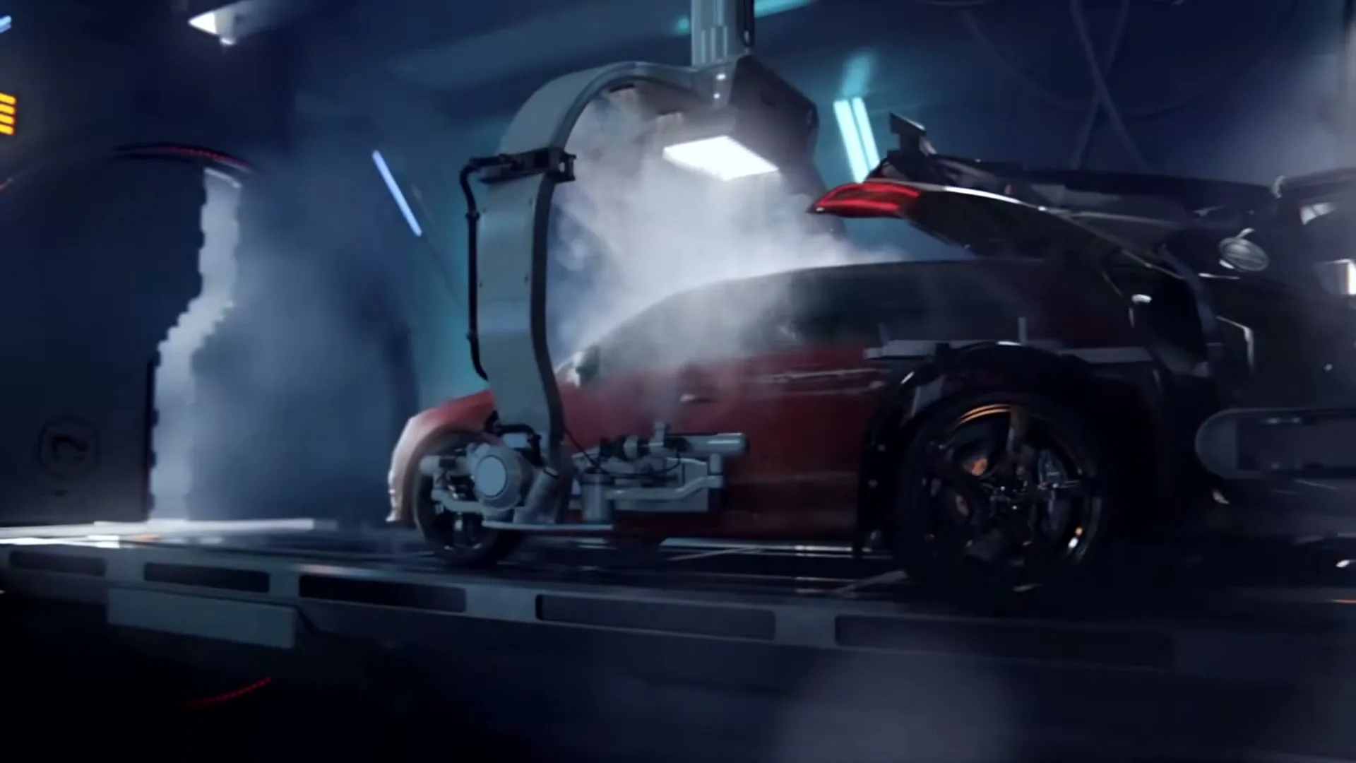 A red car is being assembled by robotic arms in a futuristic, dark factory, with smoke and bright lights illuminating the process.