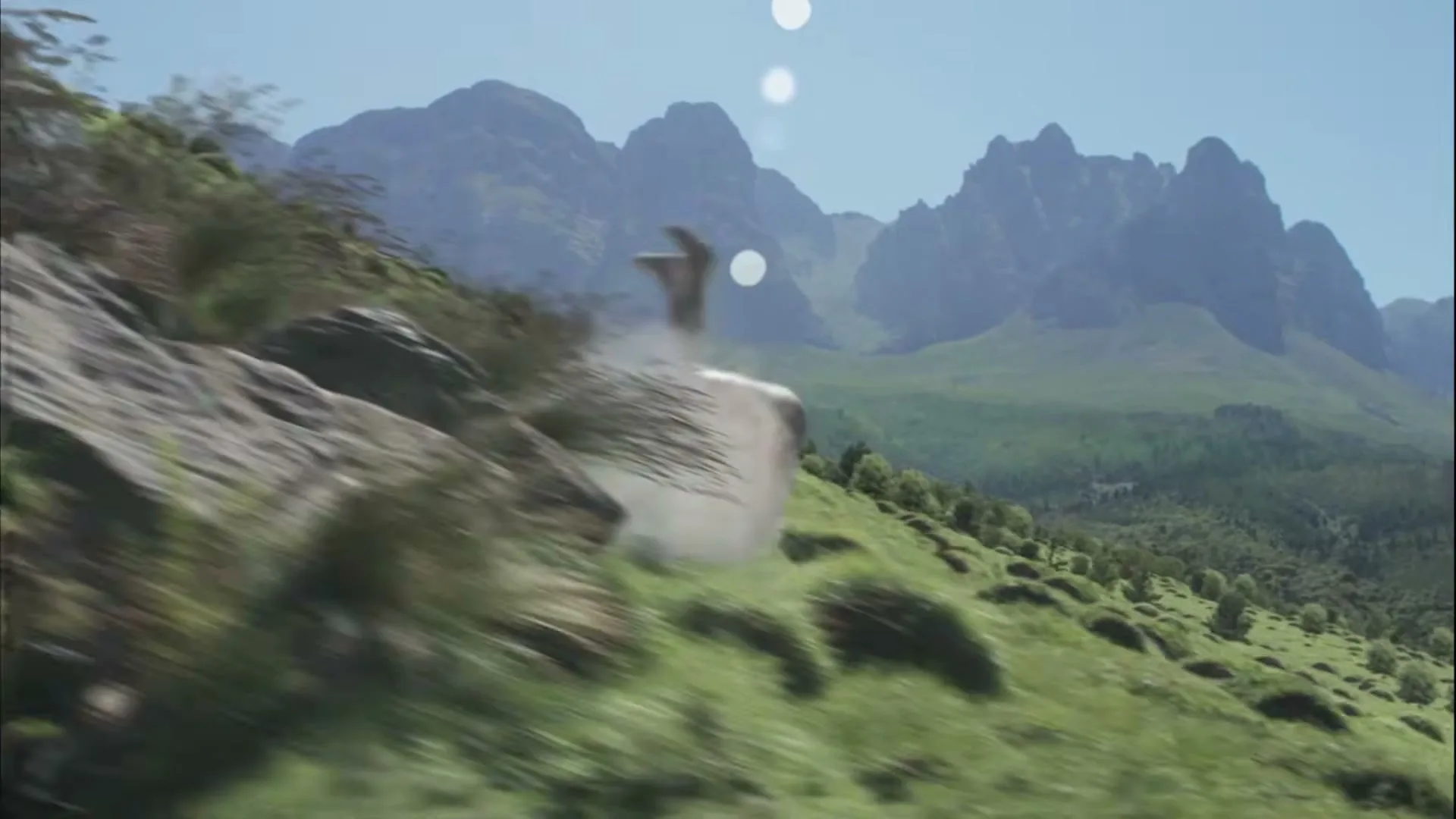 A naked person tumbles down a steep, grassy mountain slope under a bright blue sky with distant peaks.