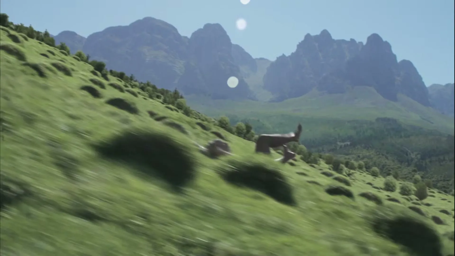 A naked man tumbles down a steep, grassy mountain slope under a clear blue sky with distant peaks.