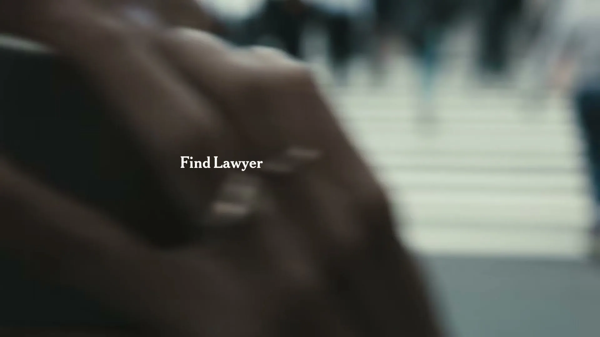 A blurry shot of people walking across a crosswalk in a city, with the words "Find Lawyer" superimposed on the screen.
