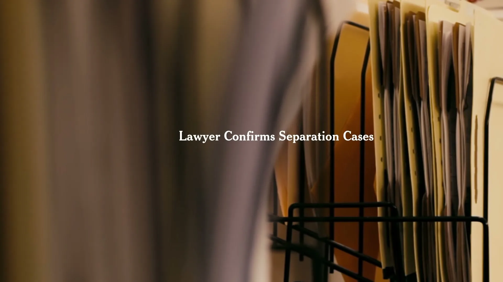 A blurred foreground object partially obscures a rack of manila folders, with the text "Lawyer Confirms Separation Cases" appearing on screen.