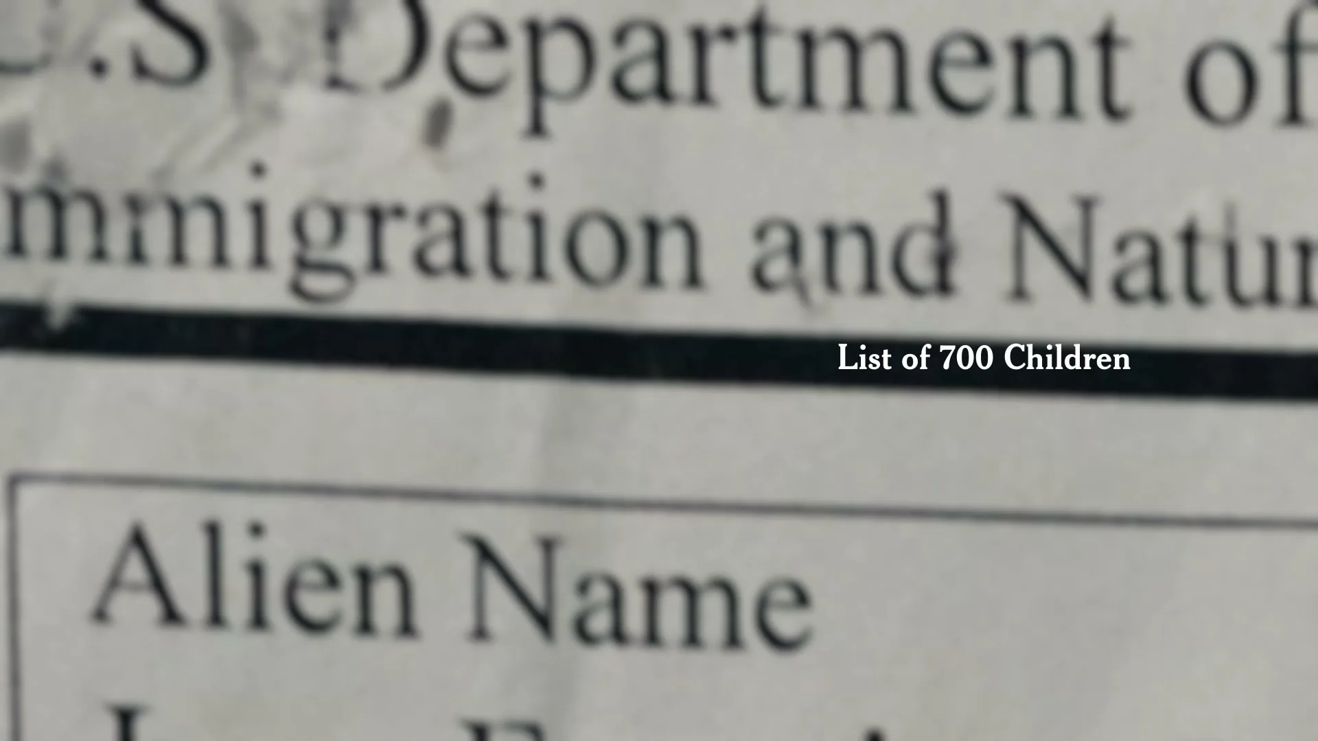 A close-up shot of a document with the words "U.S. Department of Immigration and Naturalization" and "Alien Name" visible, with "List of 700 Children" superimposed.