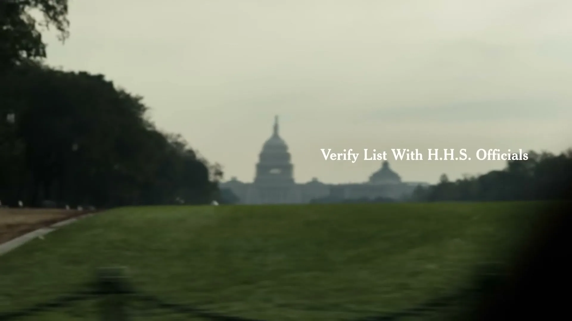 A blurry, wide shot of the US Capitol Building in Washington D.C. with green grass in the foreground and text overlayed on the image.