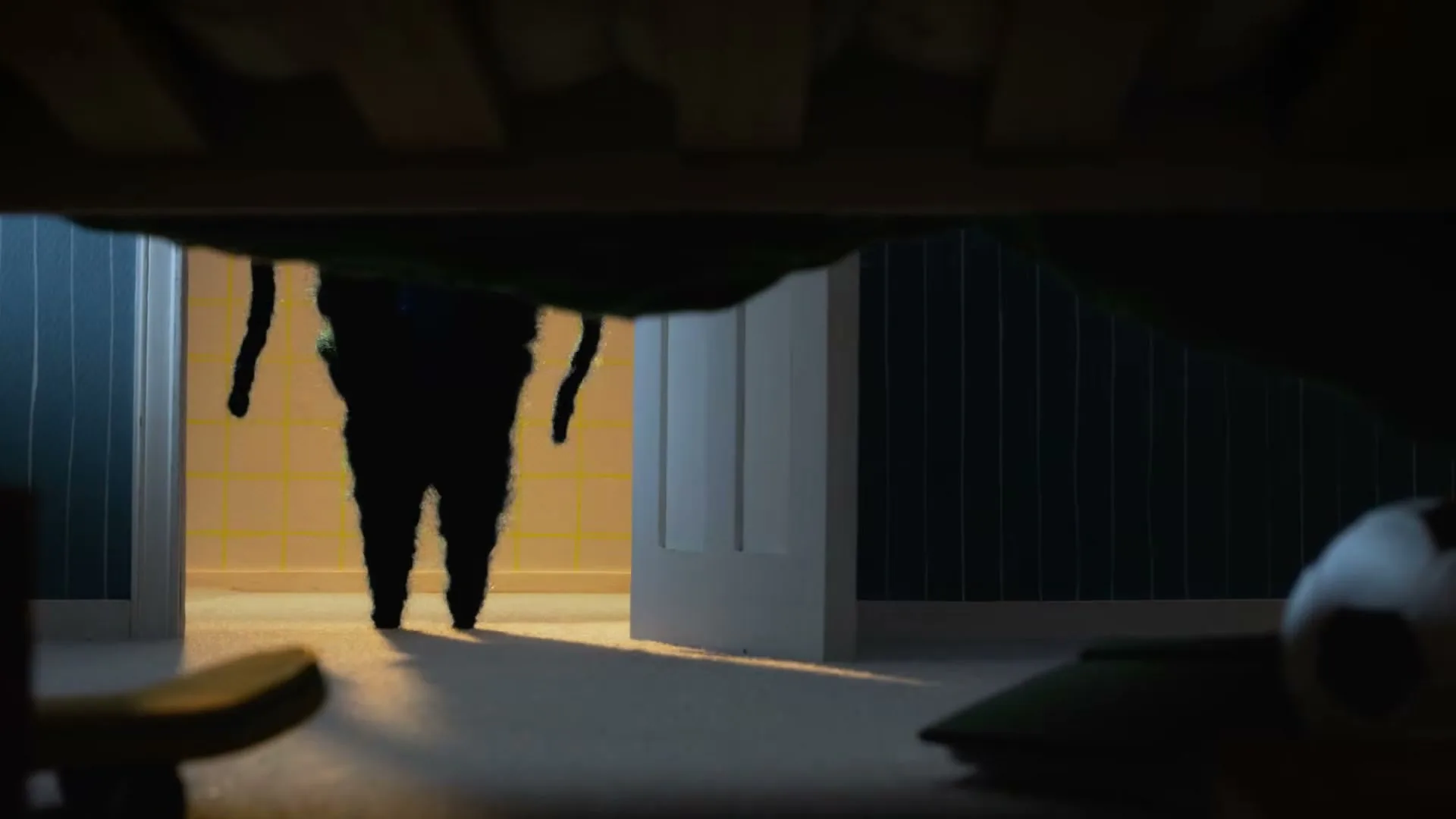 A dark, shadowy monster with long, thin arms emerges from a doorway, casting a long shadow on the floor, as seen from under a bed.