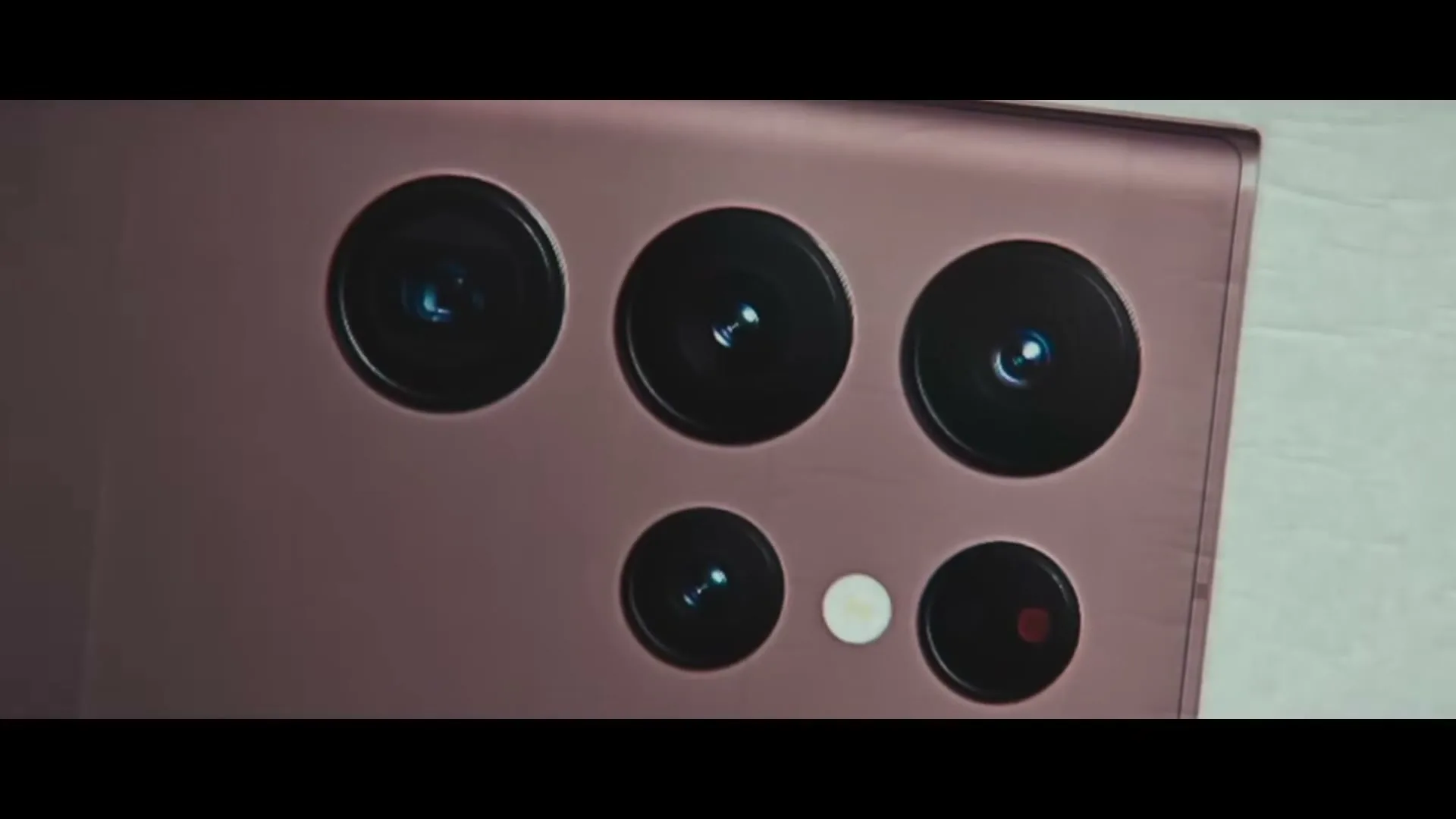 A close-up shot of the back of a purple Samsung Galaxy S22 Ultra phone, highlighting its multiple camera lenses.