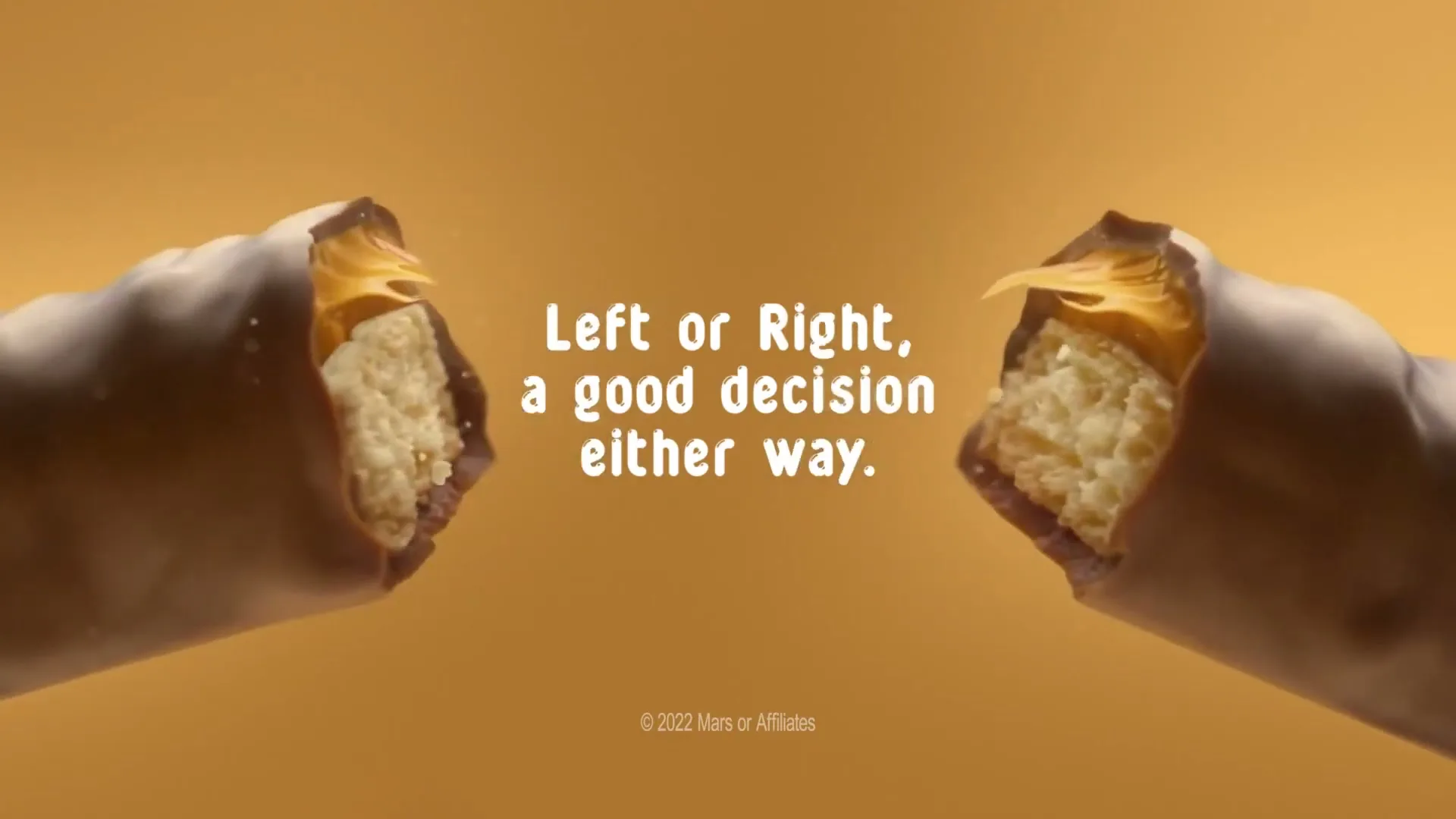 A Twix bar breaks in half, revealing its caramel and cookie layers, with the tagline "Left or Right, a good decision either way" and the Twix logo appearing on a golden background.