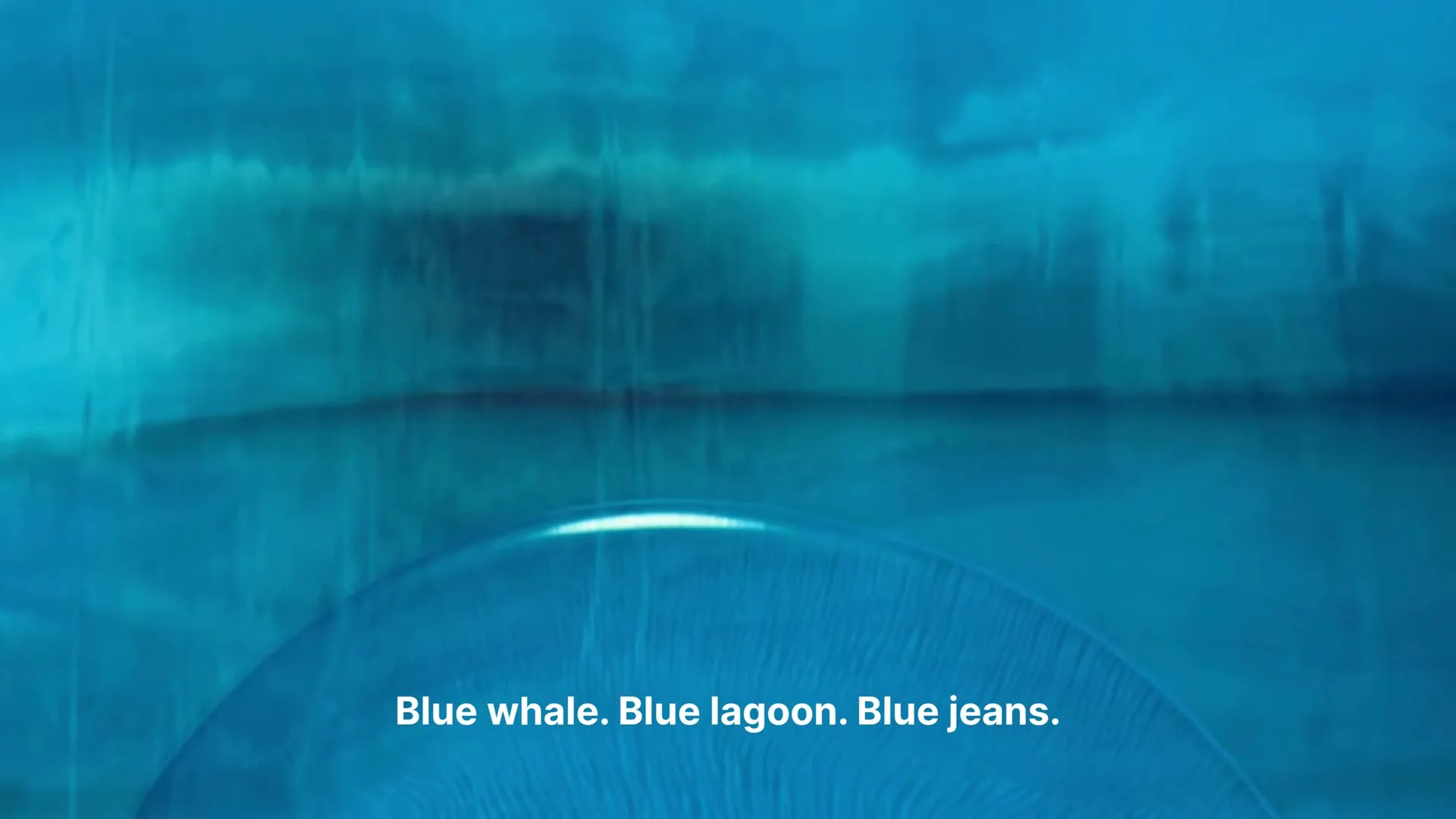 A close-up shot of a blue surface with a bright reflection, resembling water, with text overlayed.