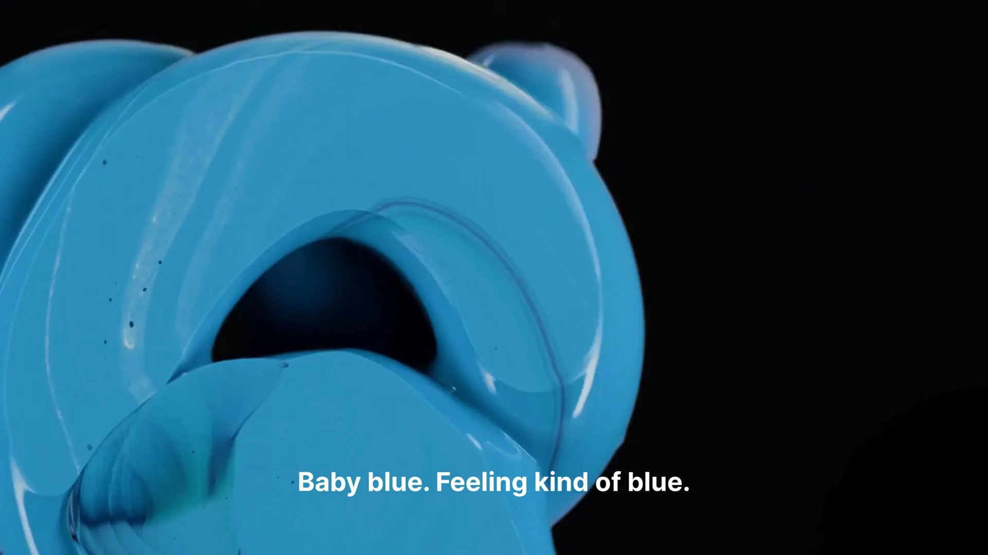 A close-up shot of a glossy, light blue, abstract 3D shape with fluid-like textures, rotating slowly against a stark black background.