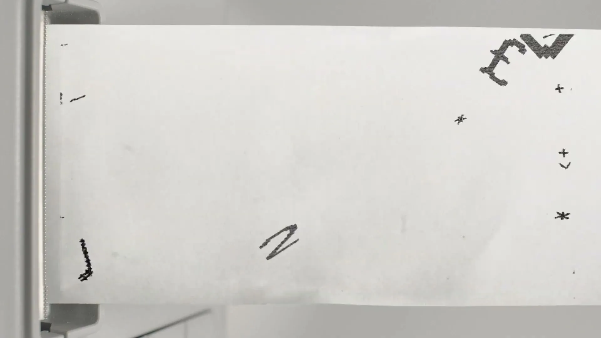 A receipt printer prints a long receipt that shows a drawing of a street with people and buildings, then the camera pulls back to reveal the full drawing.
