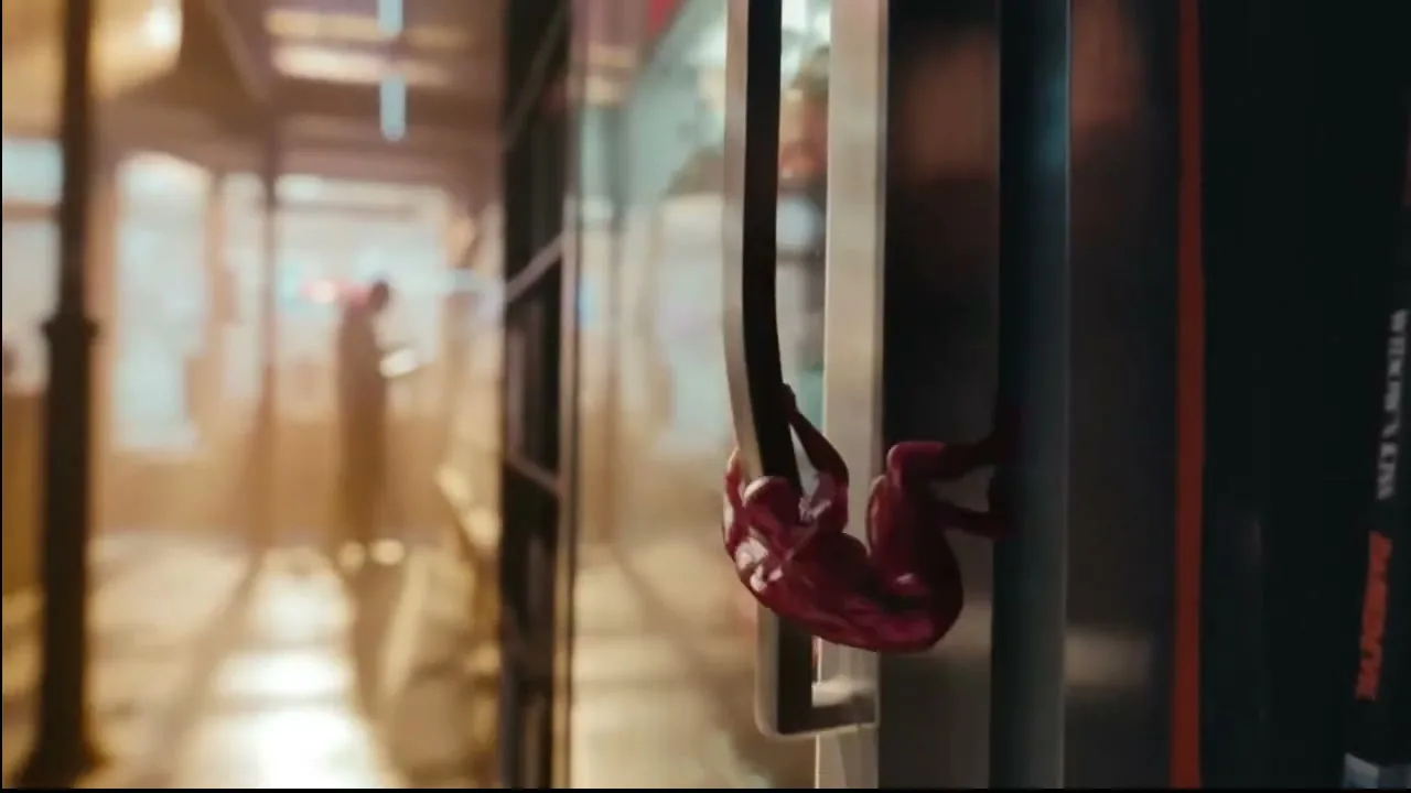A small, red, action figure-like character, resembling Daredevil, hangs from a refrigerator door handle in a convenience store.