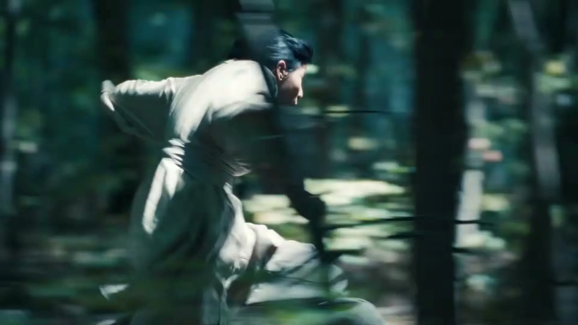 A woman in traditional clothing runs through a dense forest, her body blurred by motion as she moves quickly through the trees.