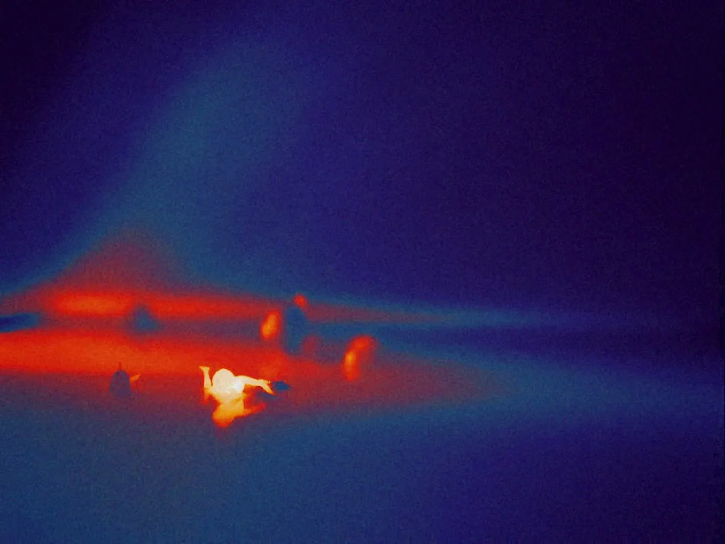 A thermal image shows a person floating in a body of water, surrounded by red and blue hues, as if in a hot environment.