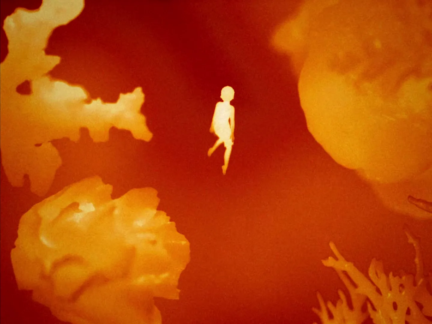 A small, glowing, human-like figure floats in a dark red, abstract space surrounded by large, amorphous orange shapes, resembling a microscopic or cosmic environment.