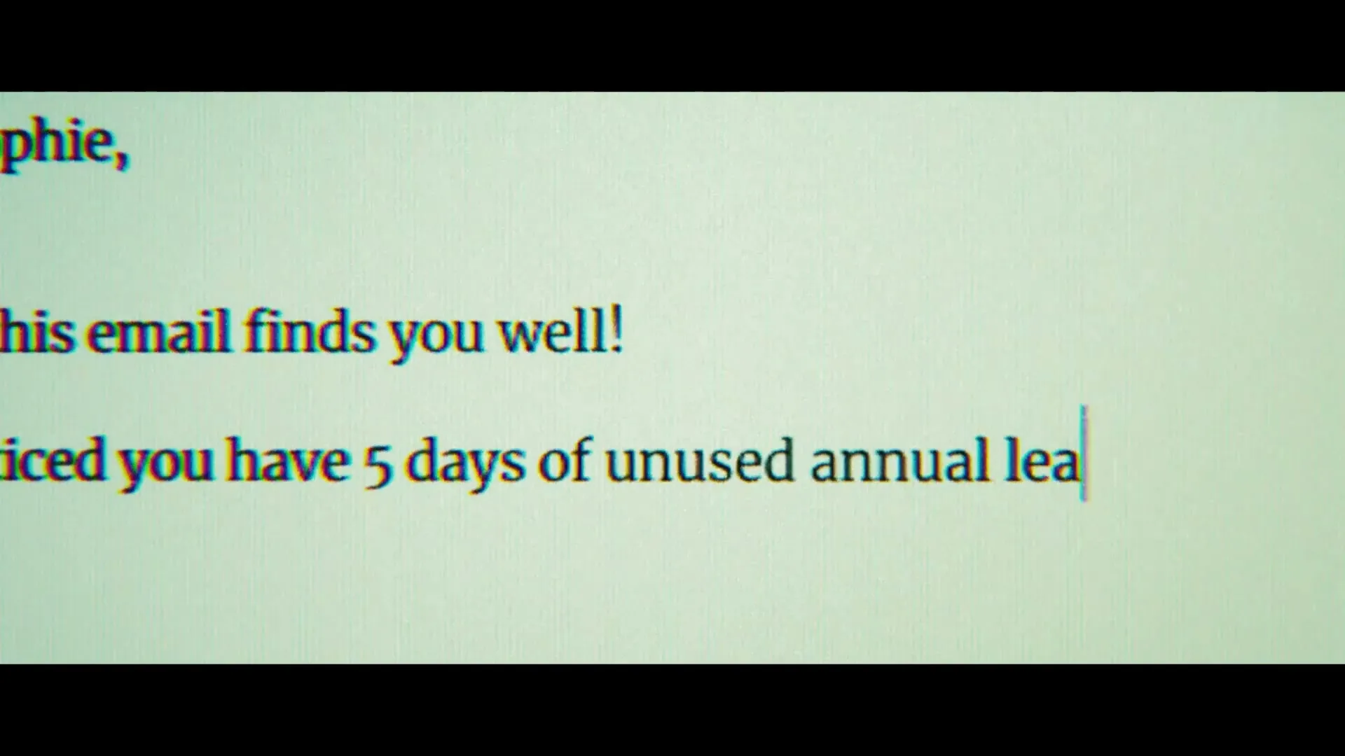 An email is shown on a screen, with text being typed out about unused annual leave.