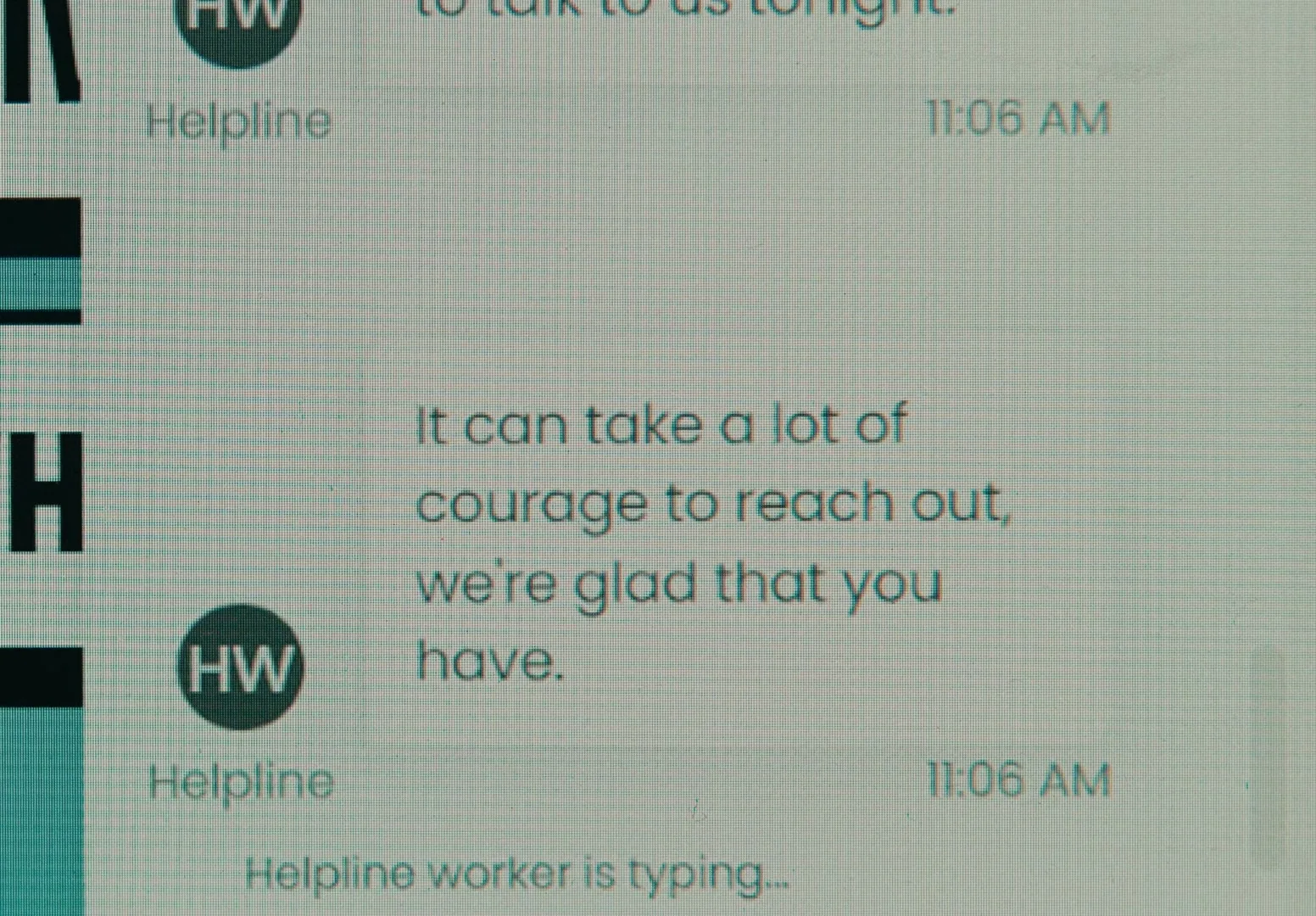 A close-up shot of a computer screen shows a chat conversation with a helpline worker typing a message.