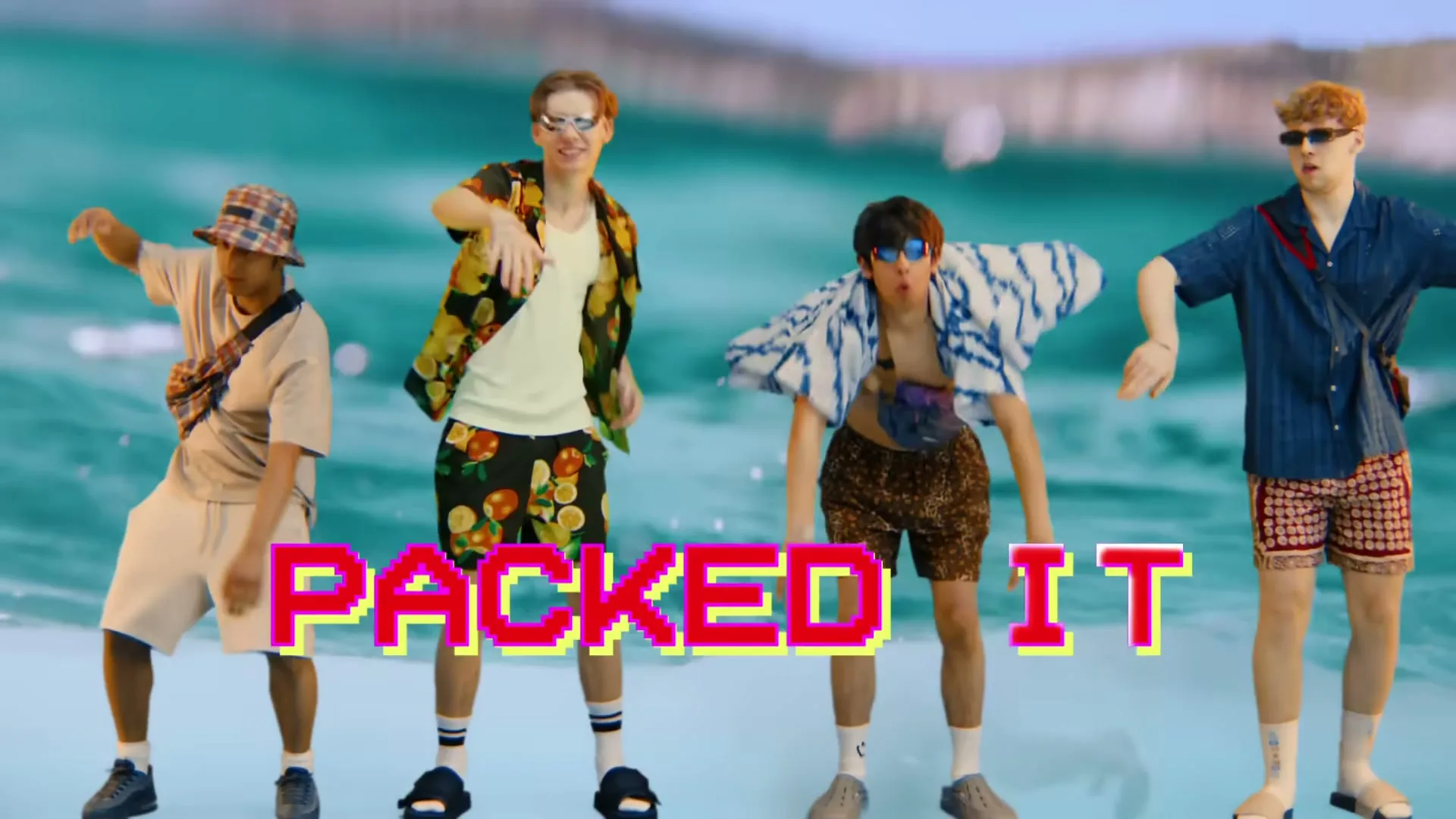 Four young men in summer clothes and sunglasses dance in front of a blue water background with the text "PACKED IT" on screen.