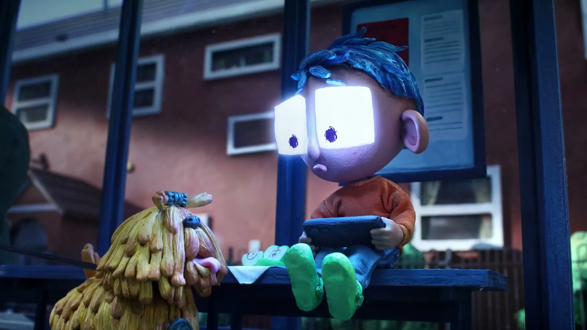 A claymation boy with glowing rectangular eyes sits on a bench, holding a tablet, next to a shaggy dog at night.
