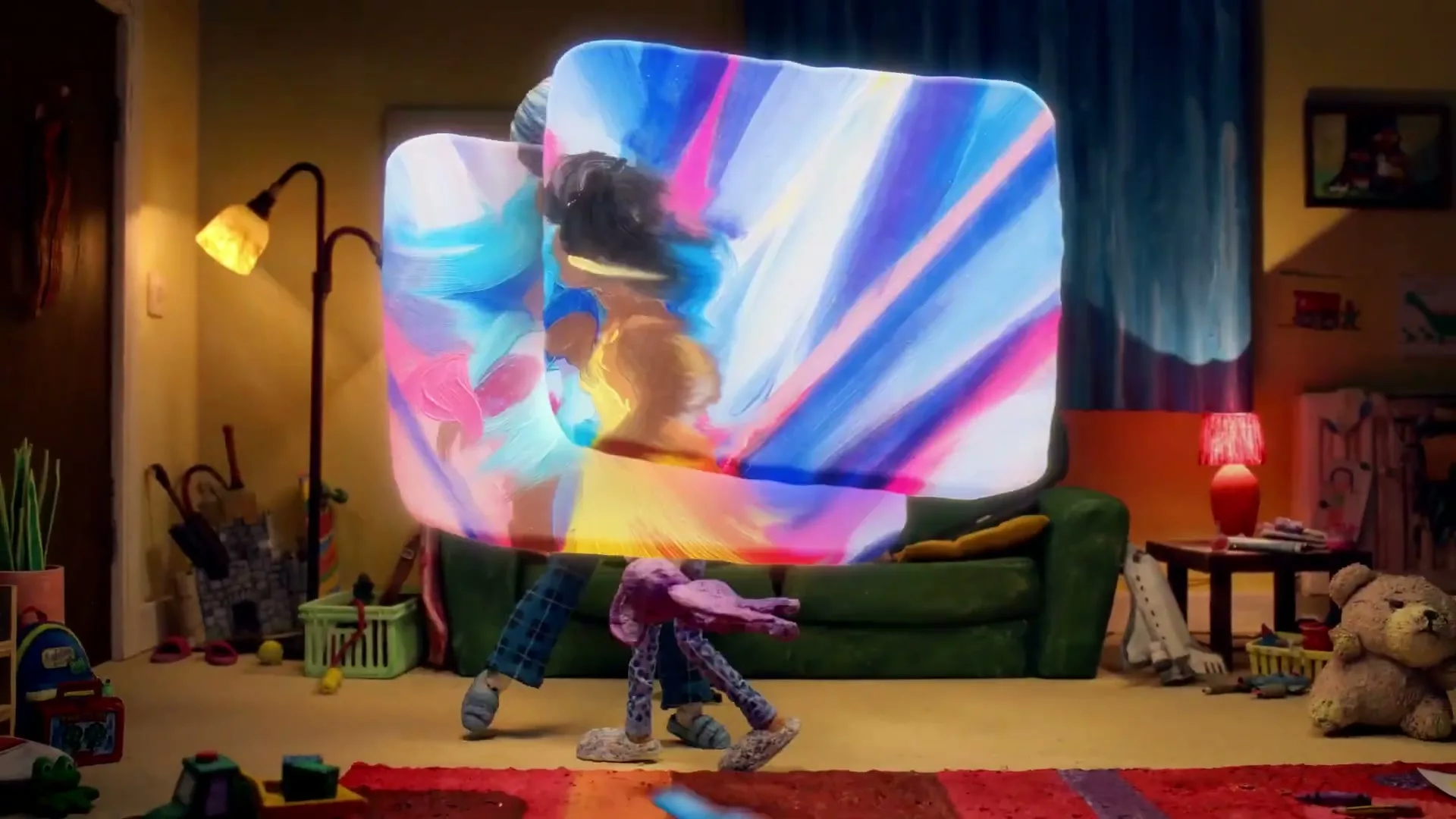 Two claymation girls hold up screens showing painted women dancing, then the screens merge and distort the room around them.