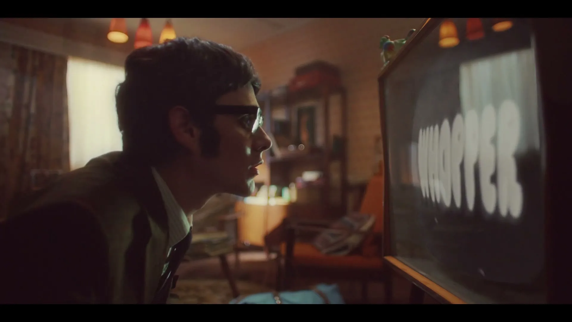 A man in a suit and glasses walks towards a vintage television, which displays a black and white image of a burger and then the word "WHOPPER" in a distorted font.