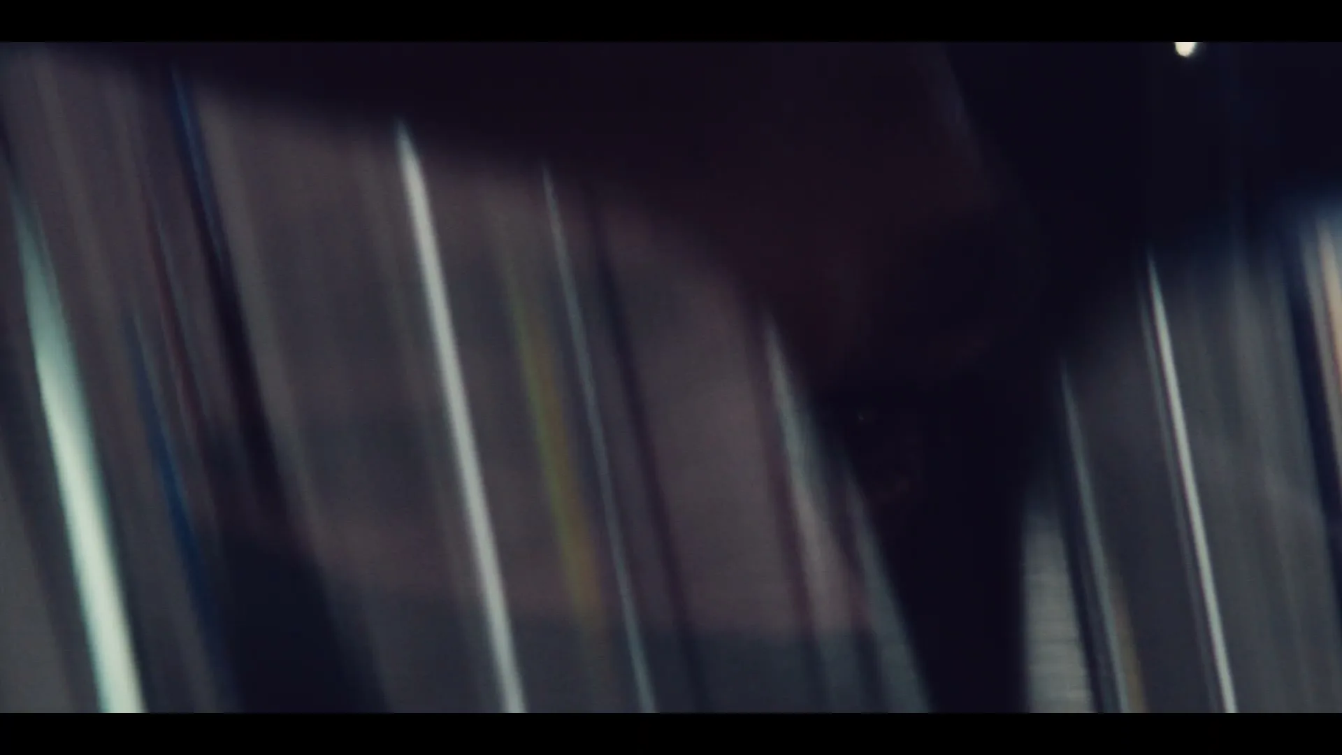 A blurry, abstract shot of a Formula E race car's side, with motion blur suggesting high speed, on a race track.