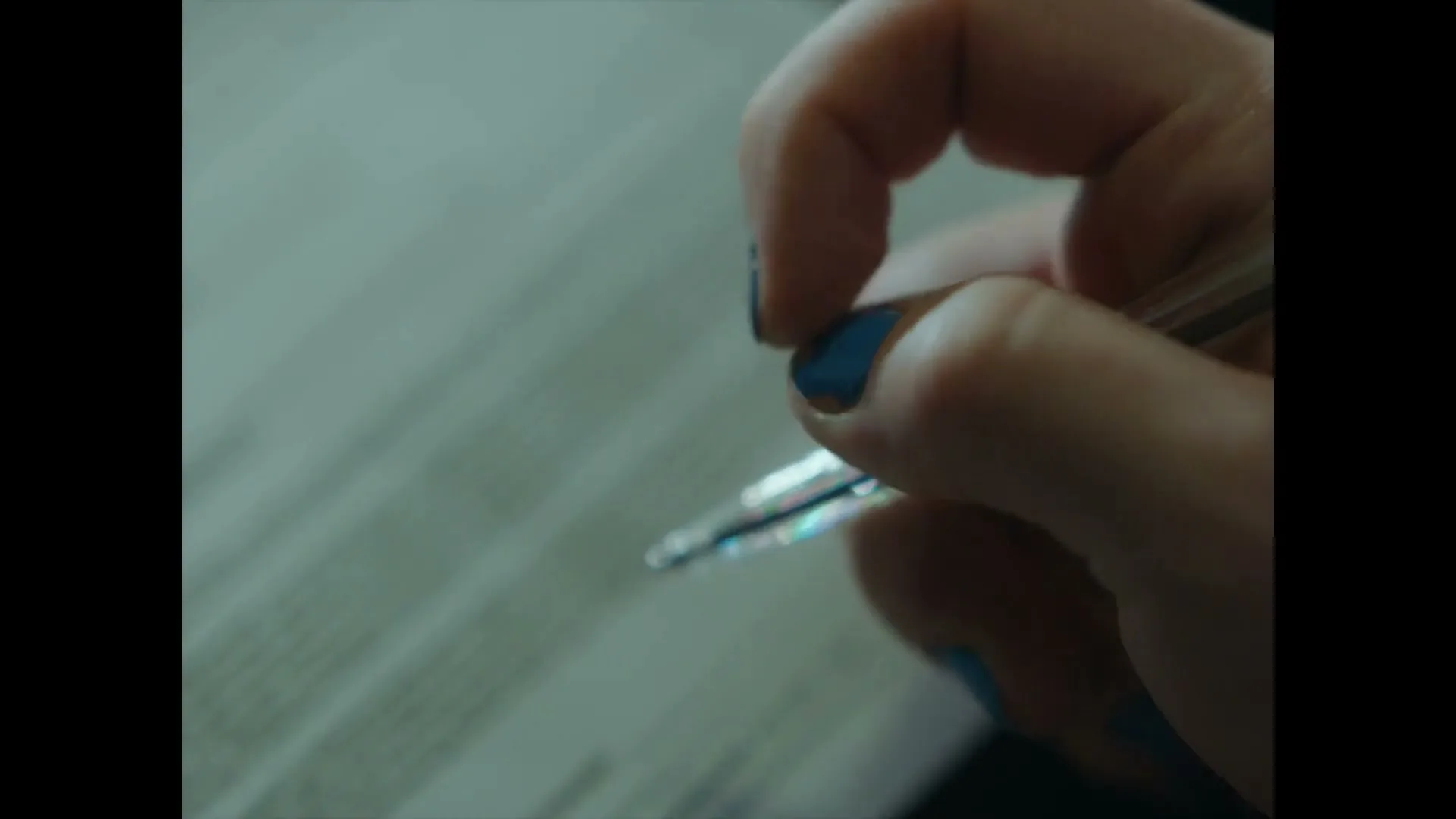 A close-up shot shows a person's hand with blue nail polish, hesitantly signing a document labeled "Patient Consent" with a pen.
