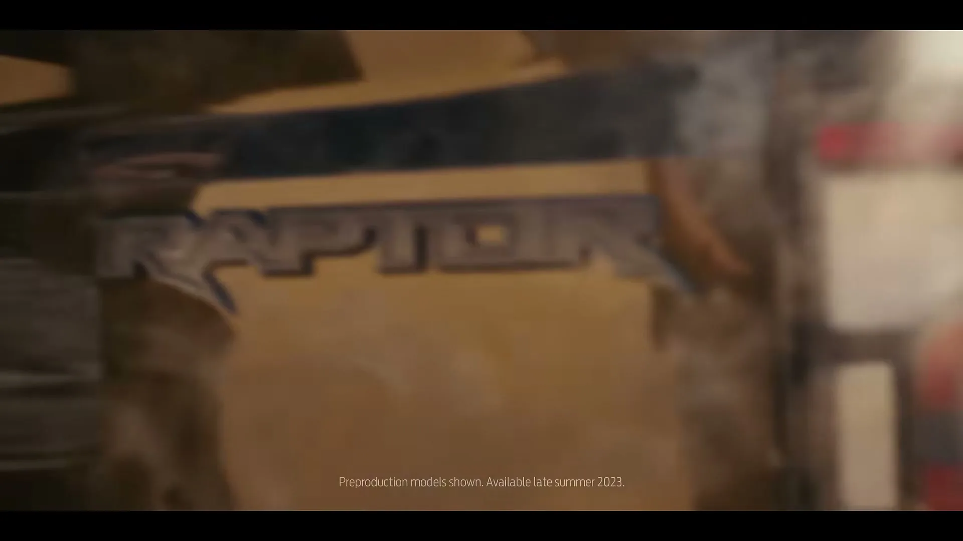 A close-up shot of the Ford Ranger's tailgate, focusing on the "Raptor" emblem as the camera racks focus.
