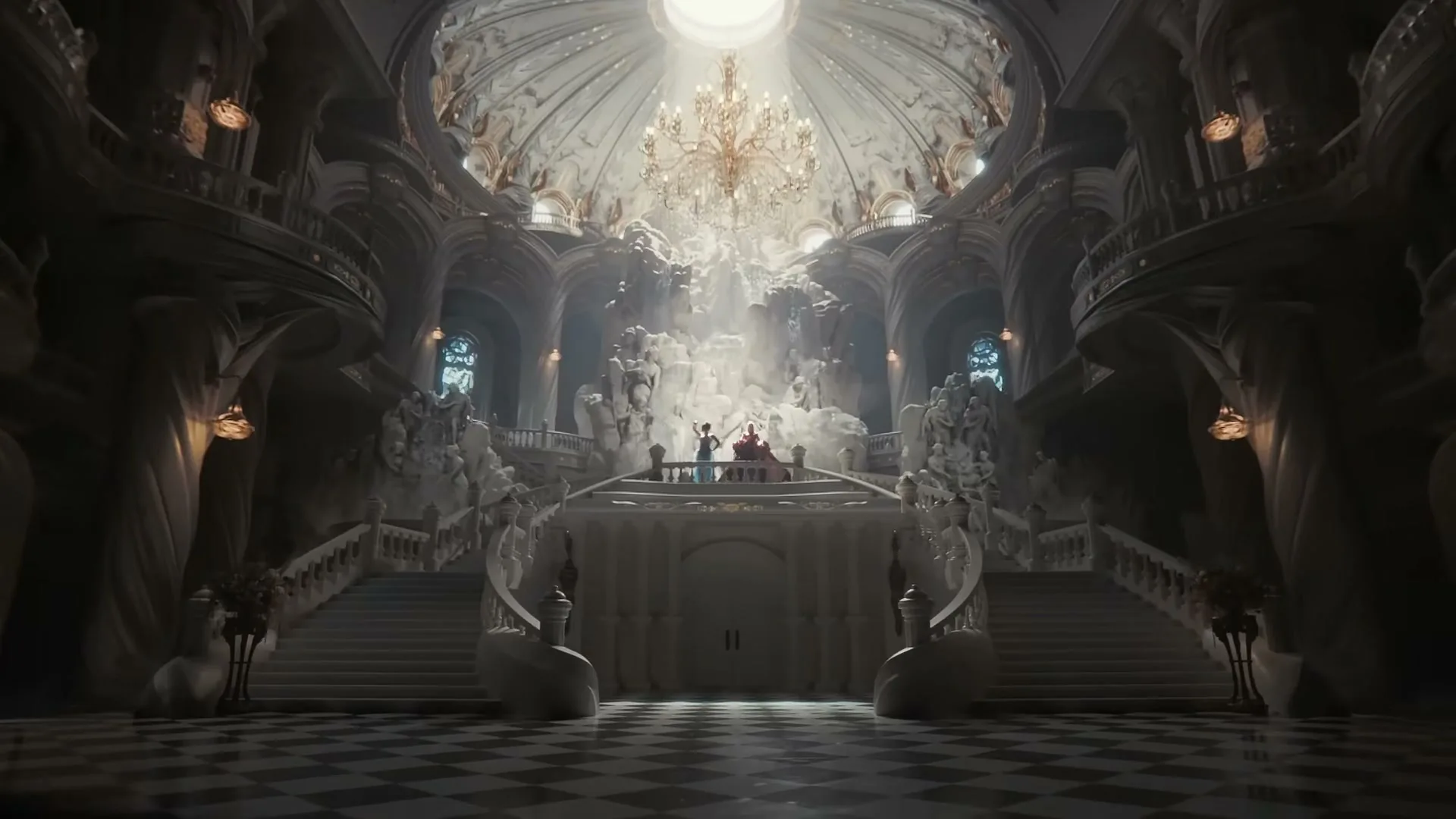 A wide shot of a grand, ornate hall with a high domed ceiling and a large chandelier, as two figures stand on a balcony.