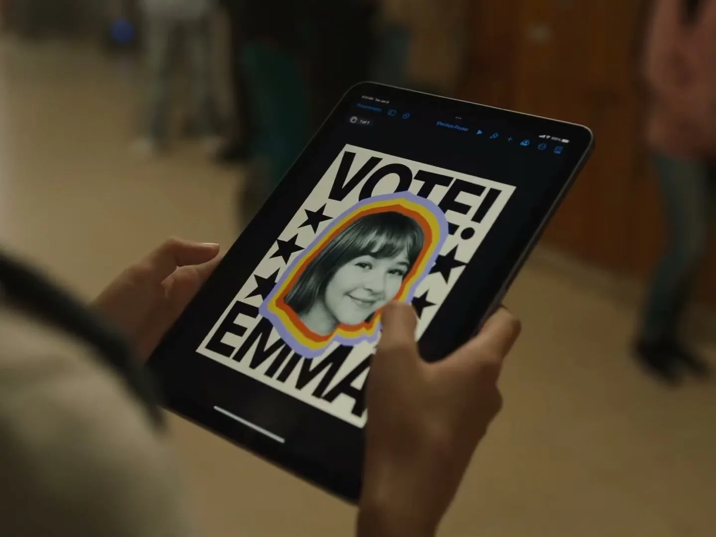 A person holds an iPad displaying a "VOTE! EMMA" election poster, then an AirDrop notification for "MAX" appears, in a school hallway.