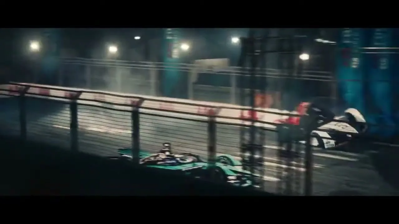 A green Formula E race car crashes into a barrier on a wet track at night, with sparks and debris flying.