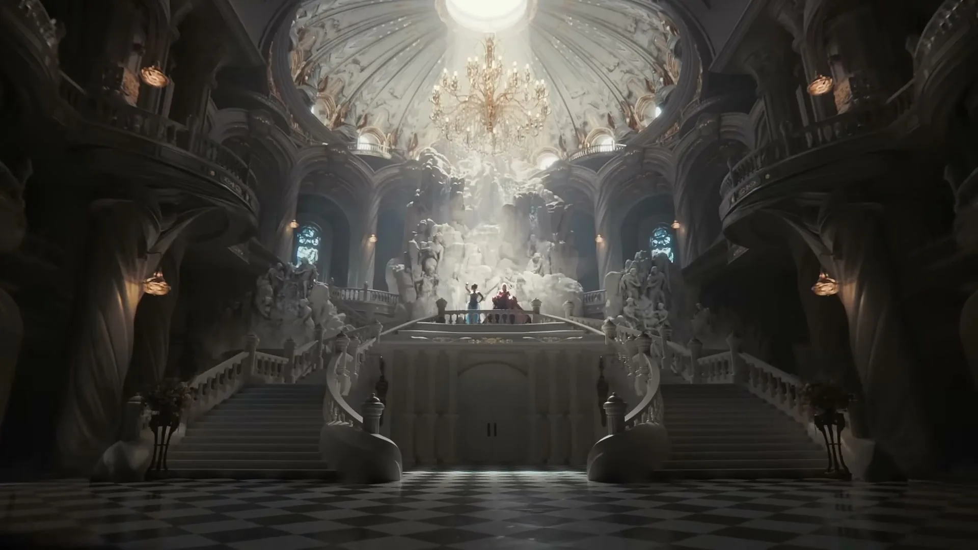 A wide shot of a grand, ornate hall with a high domed ceiling and a large chandelier, where two small figures stand on a balcony.
