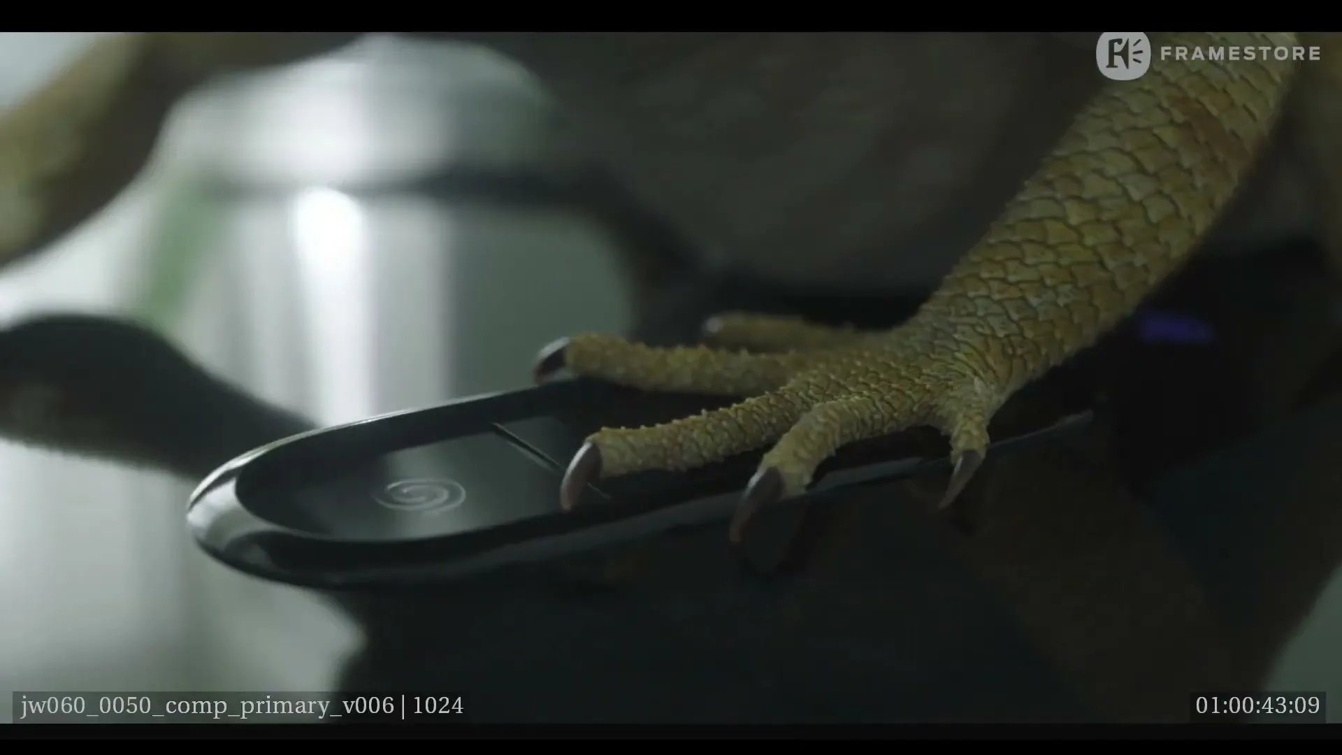 A scaly, reptilian hand with sharp claws presses down on a black smartphone on a reflective surface.