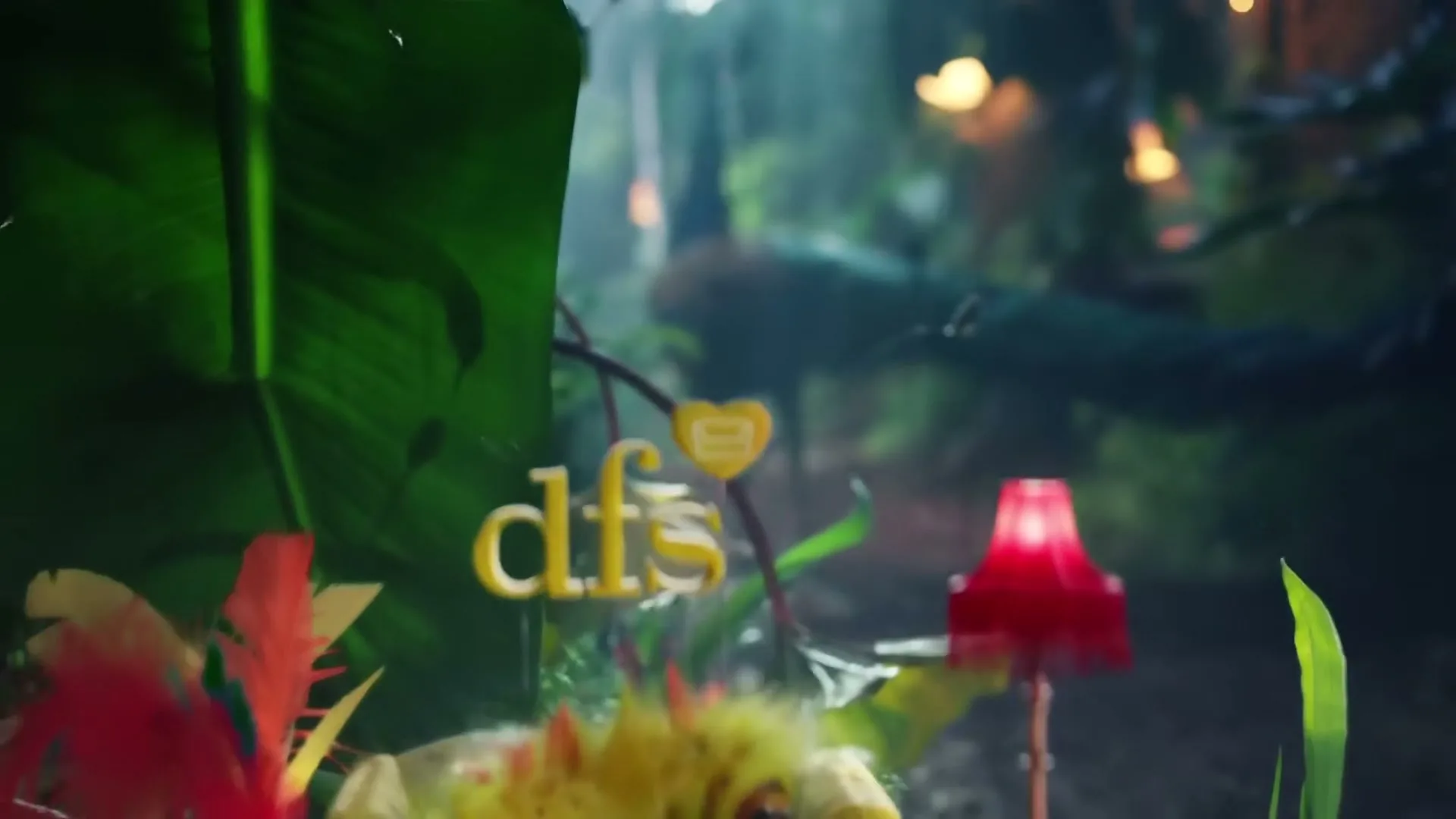 A fluffy yellow caterpillar with orange spikes rests on a miniature yellow sofa, surrounded by oversized jungle plants and a red lamp, as the camera pulls back to reveal a peacock walking through a lush, misty jungle.