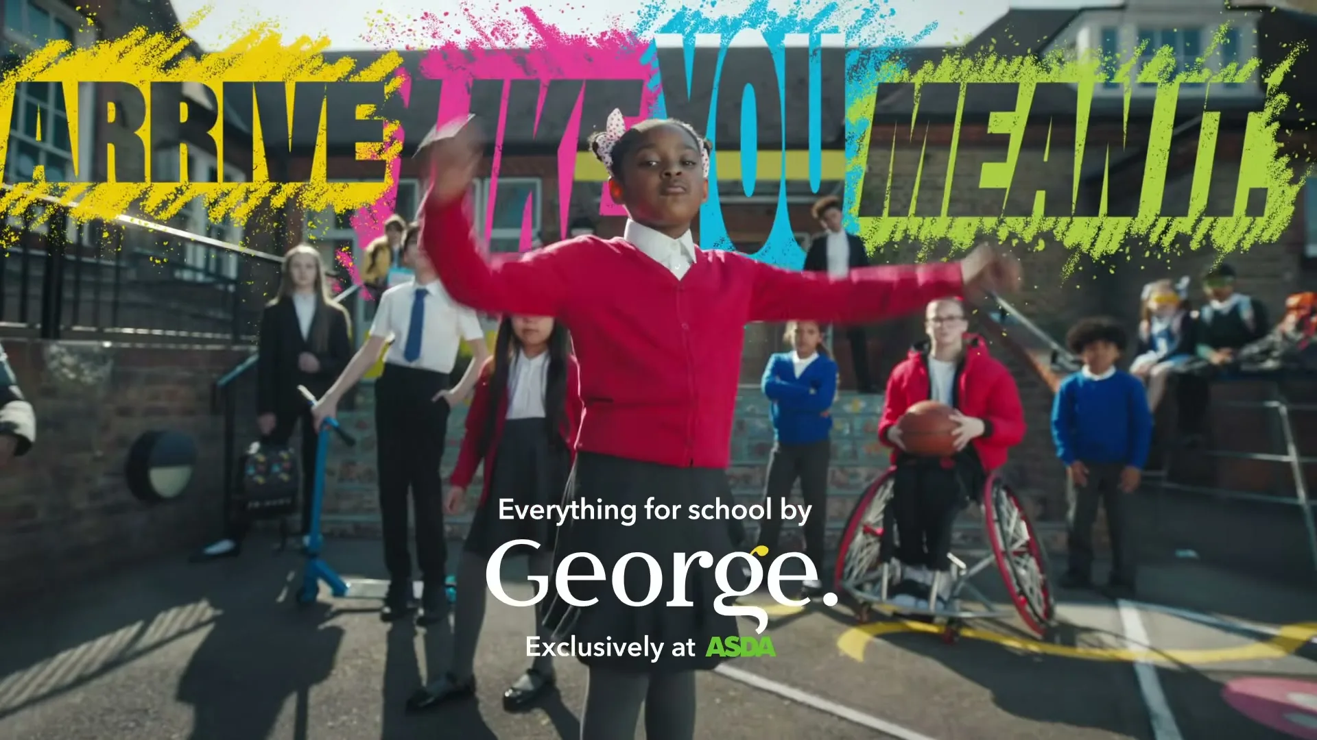 A diverse group of school children in uniforms stand in a sunny schoolyard, with a girl in a red cardigan dancing in the foreground, and text overlays.