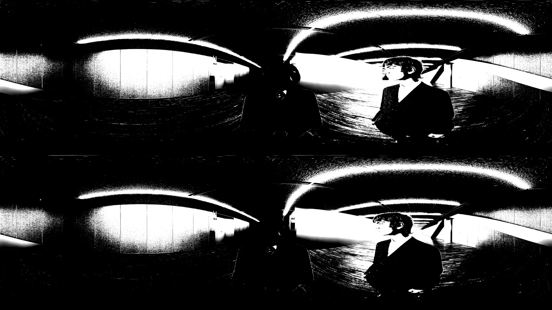A young man in a dark suit and white turtleneck walks towards the camera in a stark, high-contrast black and white tunnel.