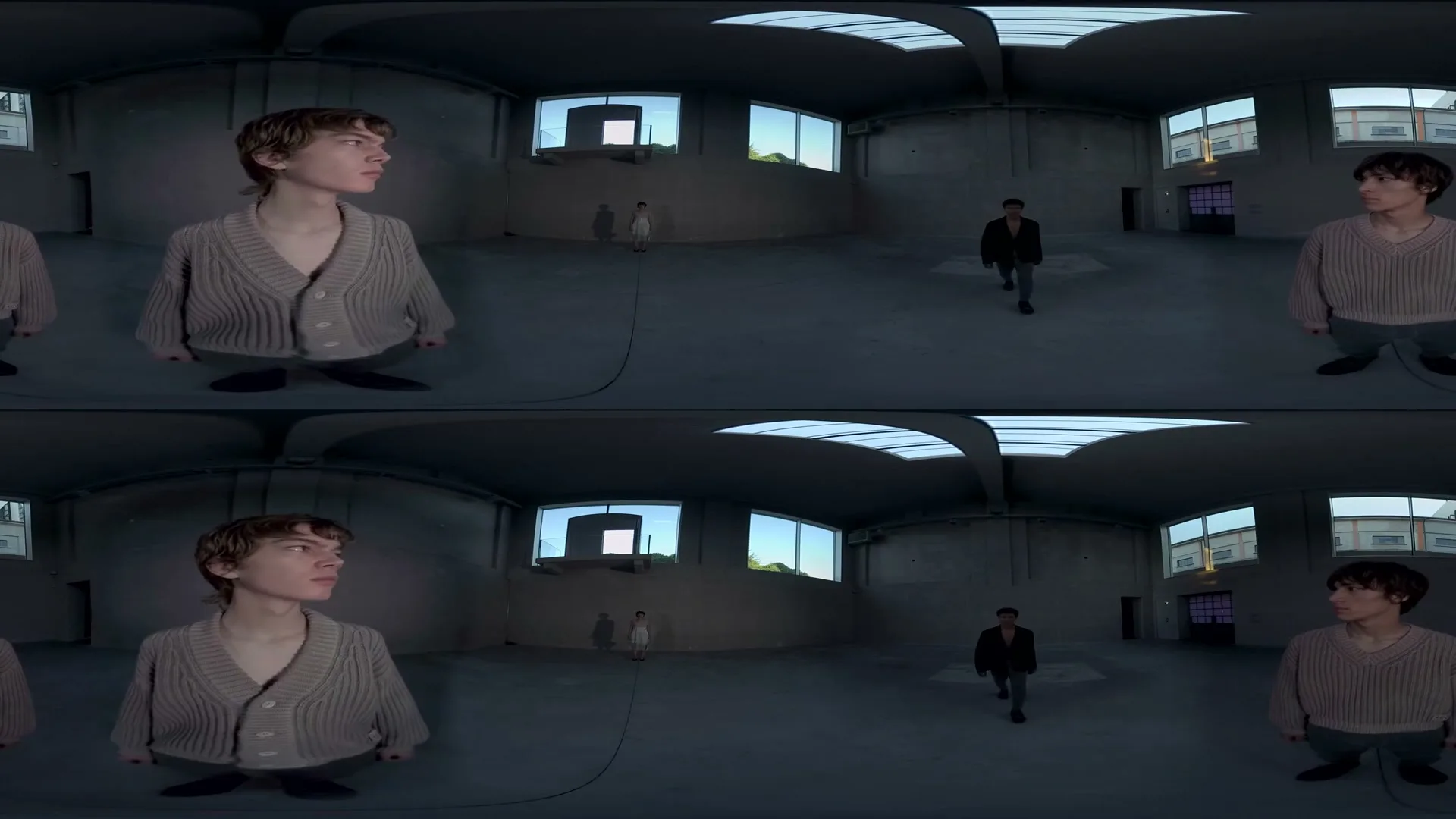 Four models, two male and two female, are seen in a large, empty industrial space with windows and skylights, captured in a 360-degree split-screen view.