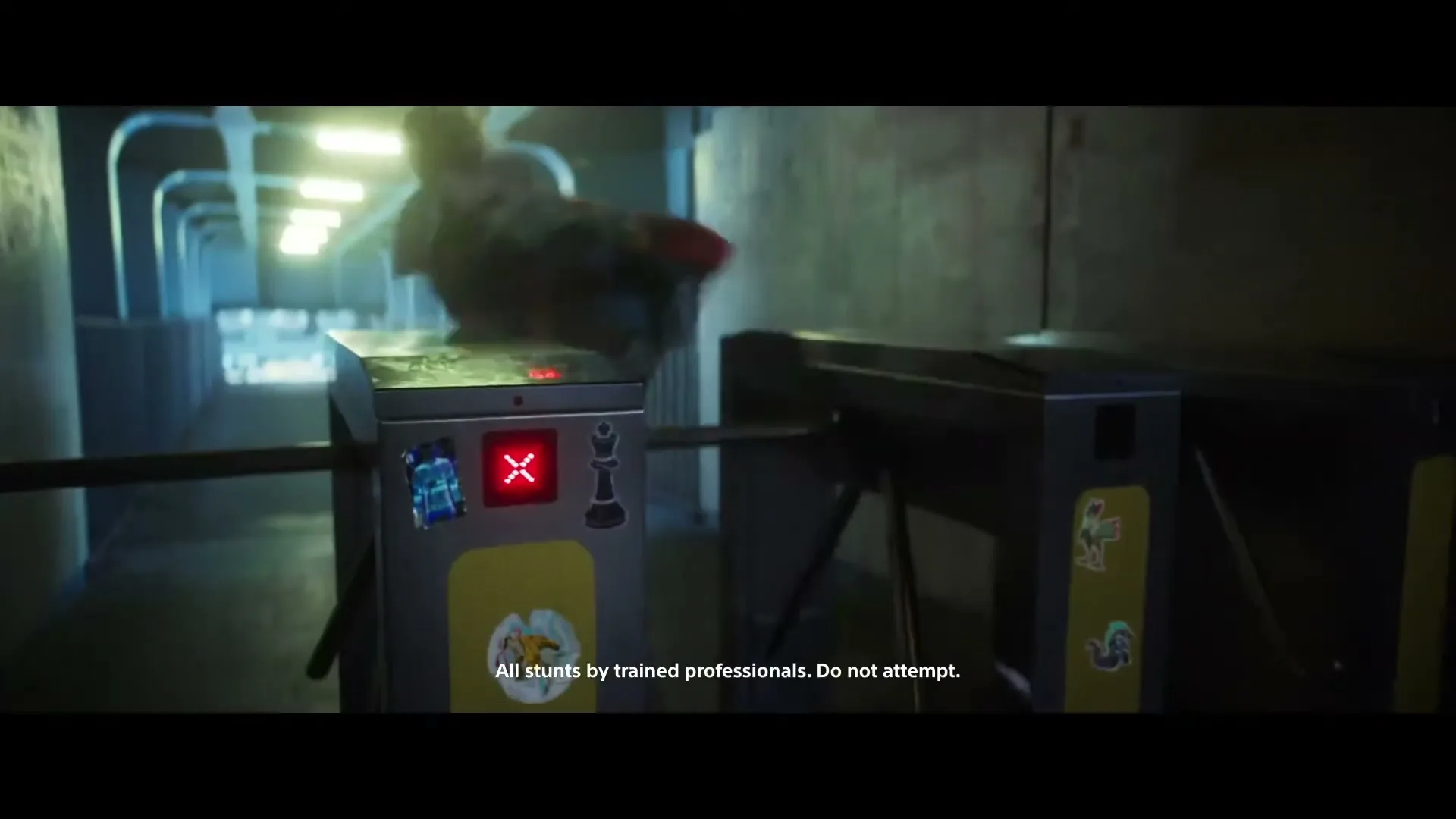 A person in a hoodie jumps over a turnstile in a dimly lit, futuristic-looking subway station or tunnel.