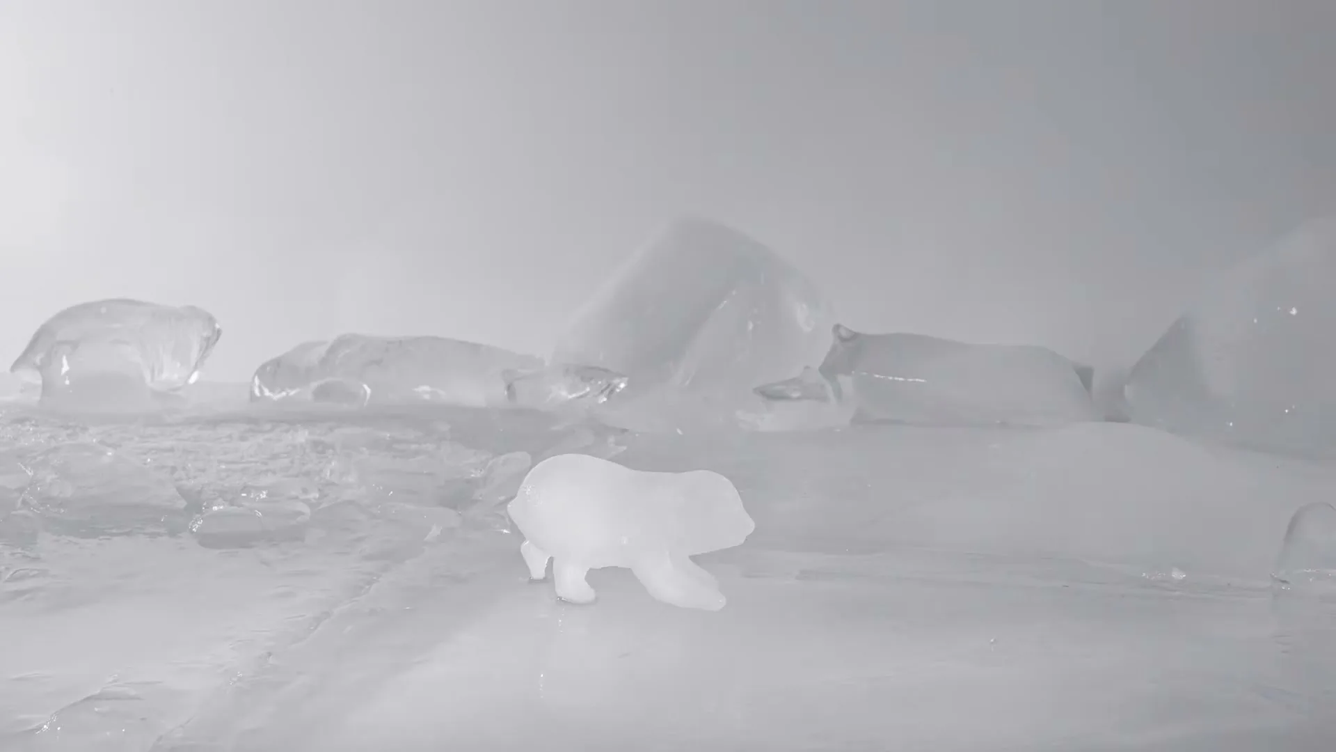 A small ice sculpture of a polar bear melts on a surface of ice and water, surrounded by larger ice chunks, in a studio setting.