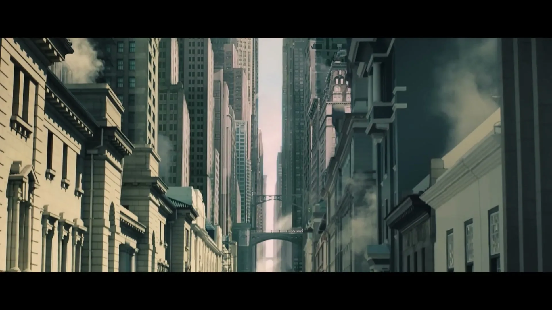 A wide shot of a deserted city street with tall buildings on either side, and a bridge connecting two buildings in the distance, with smoke rising from the street.