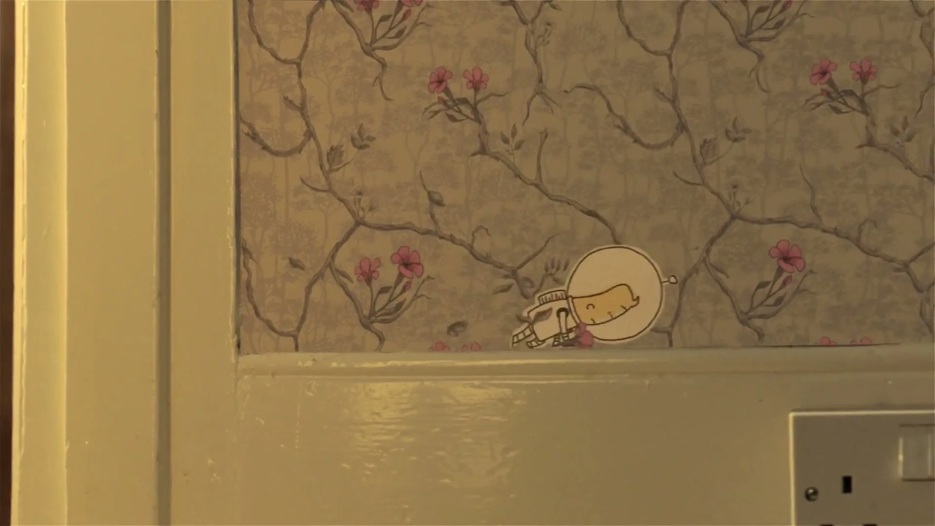 A cutout animation of a male astronaut character floats across a floral wallpaper, holding a bouquet of flowers, in a medium shot.