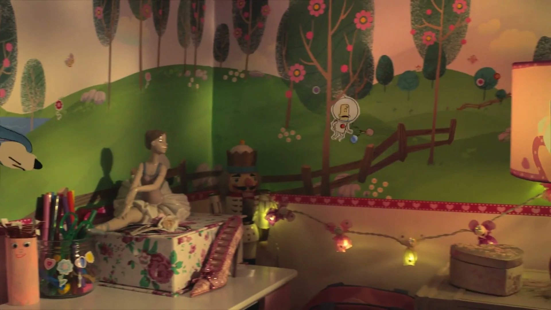 A child's bedroom with a colorful mural on the wall, featuring a ballerina doll and a lamp with a ballerina design, as the camera pans right.
