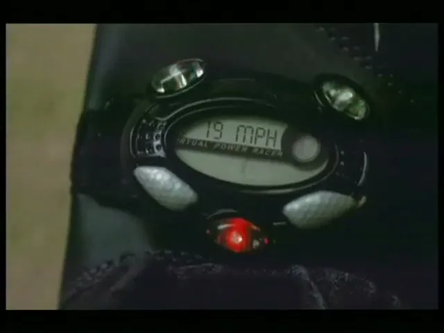 A close-up shot of a black shoe with a digital device attached, displaying "19 MPH" and animated running figures.