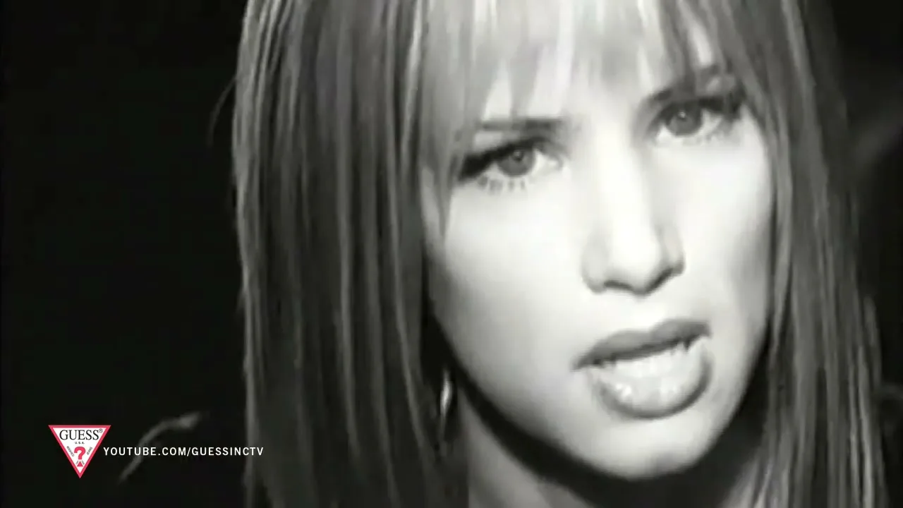 A young woman with long hair and bangs looks directly at the camera with a concerned expression in a black and white shot.