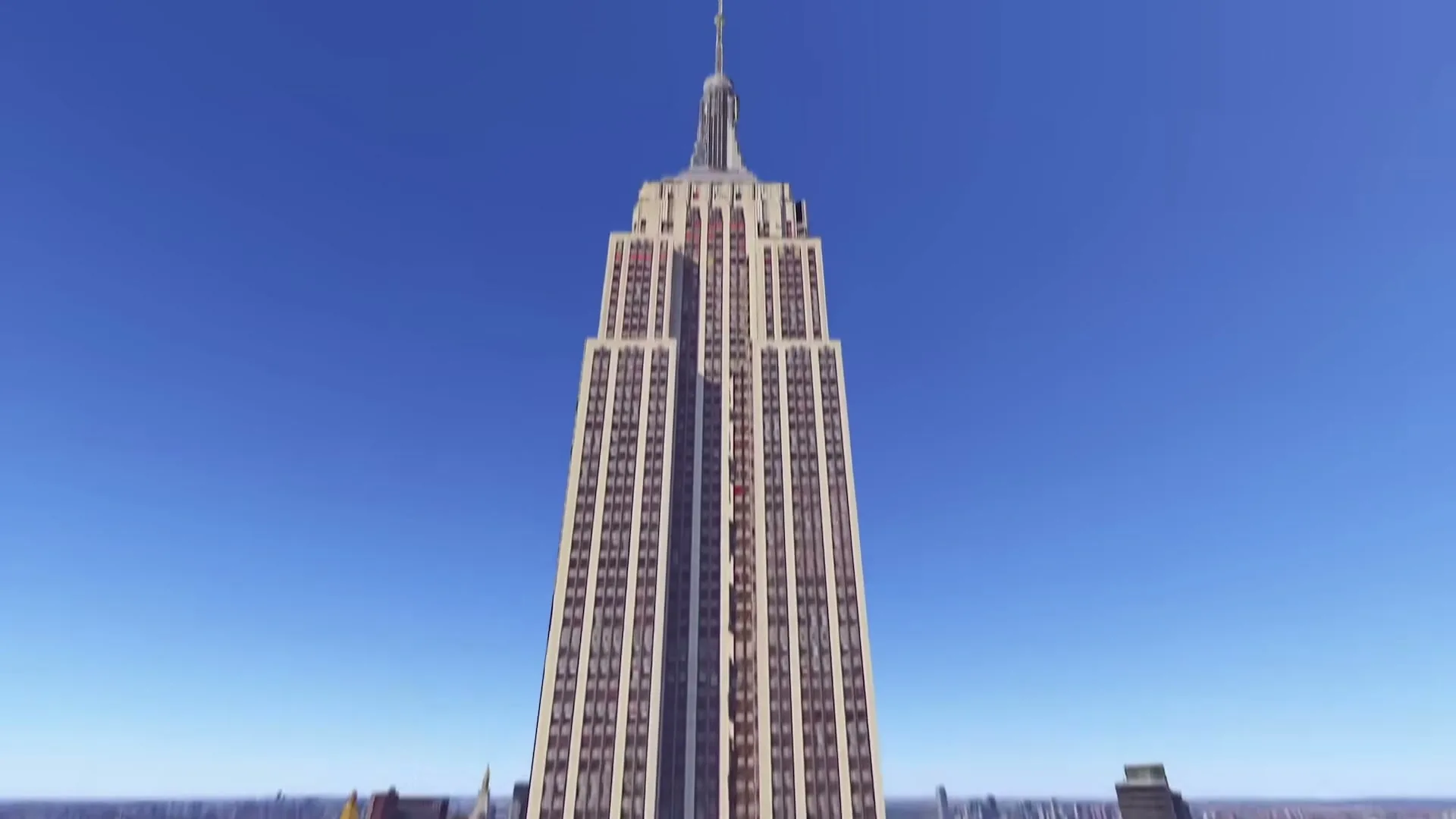 An aerial view of New York City shows the Empire State Building, then the camera zooms in and pans around the building.
