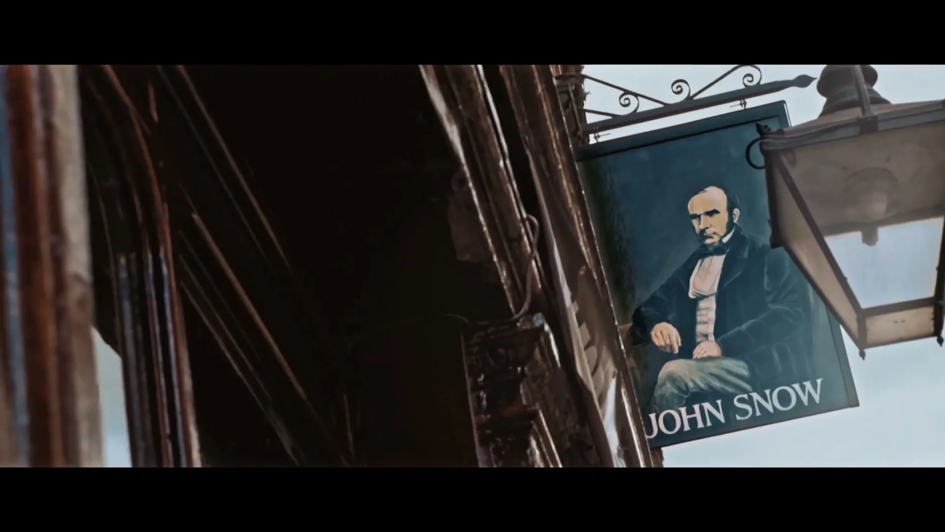 A close-up shot of a pub sign featuring a portrait of John Snow, hanging outside a building in Soho.