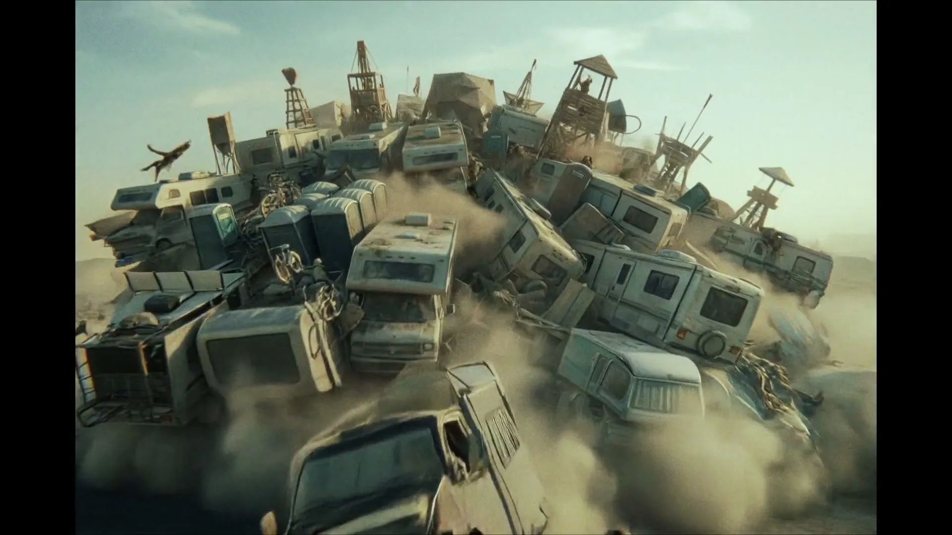 A giant ball of RVs, trucks, and portable toilets rolls across a dusty desert landscape, with tiny figures scrambling around it.