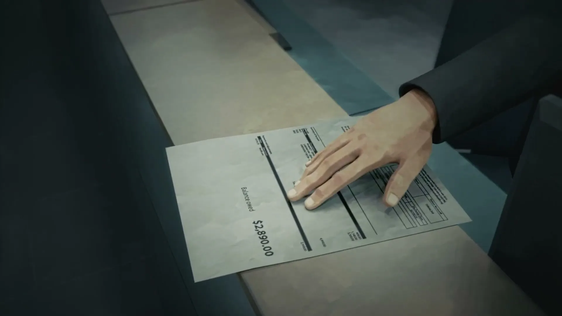 A person's hand is seen on a hospital bill with a balance owed of $2,890.00, on a counter in a hospital.