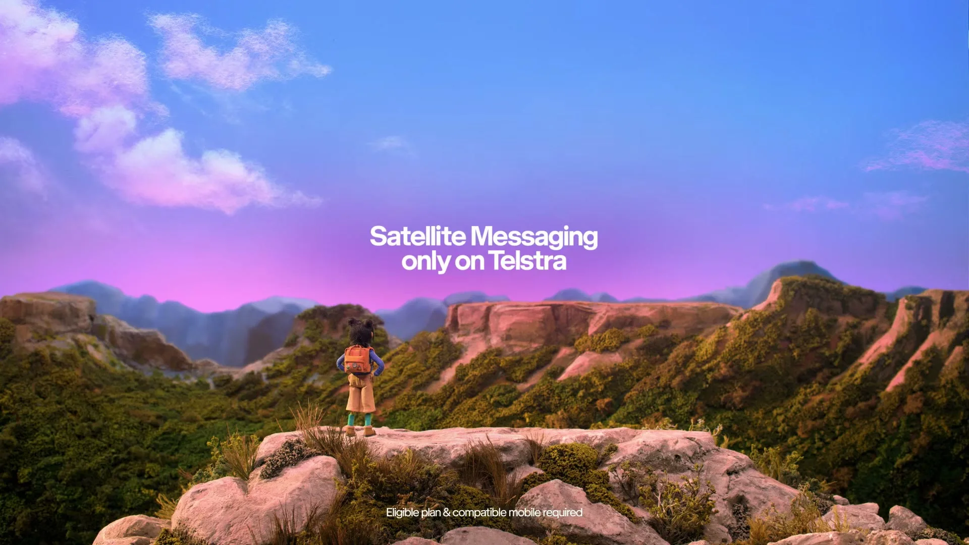 A young hiker stands on a rocky outcrop, looking out over a vast, lush valley under a vibrant sky, with text overlays about satellite messaging.